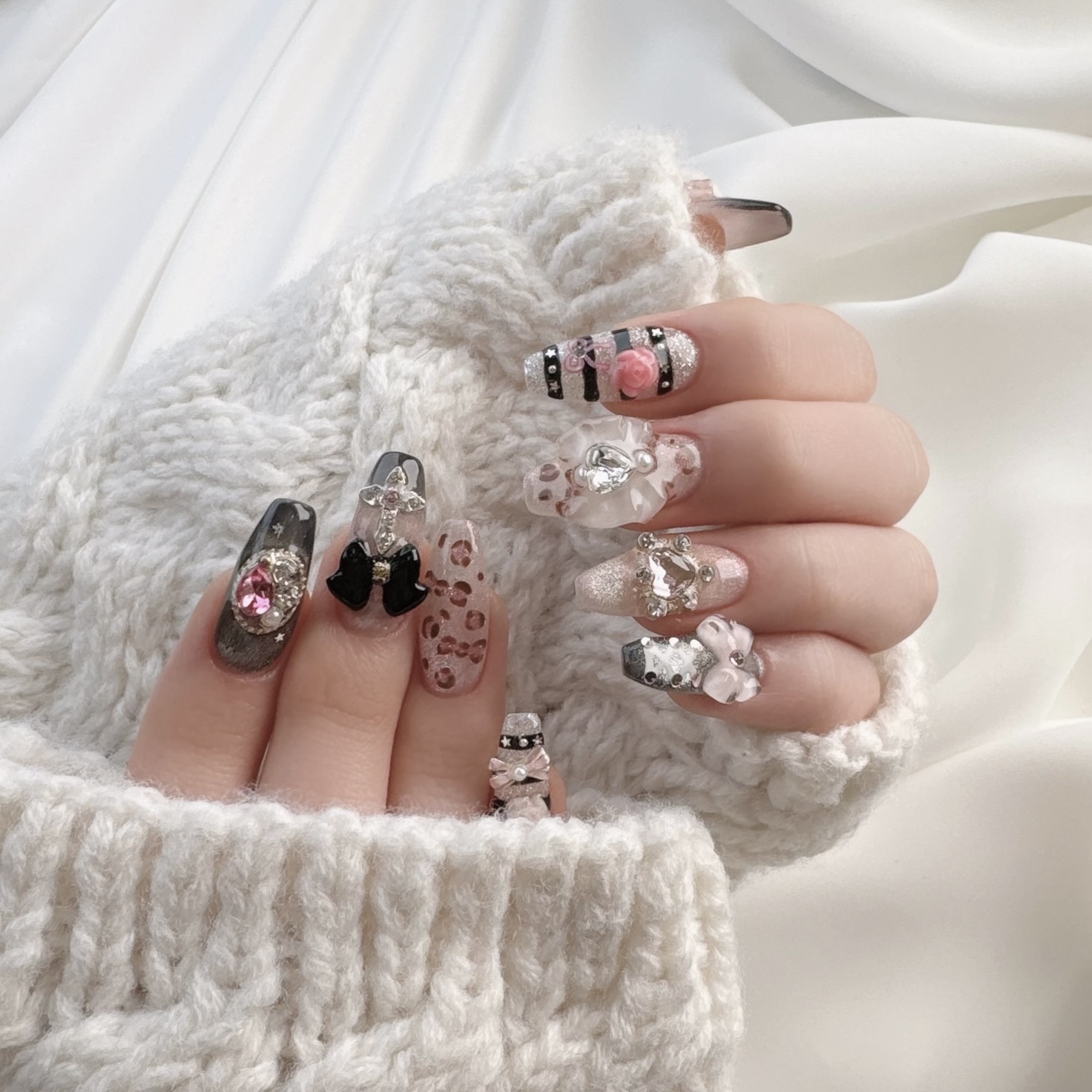 Decorative nail art with 3D bows, rhinestones, and animal prints on sculpted nails