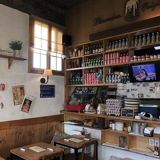 Cozy interior wooden shelving unit with dining tables at Pancake Original Story