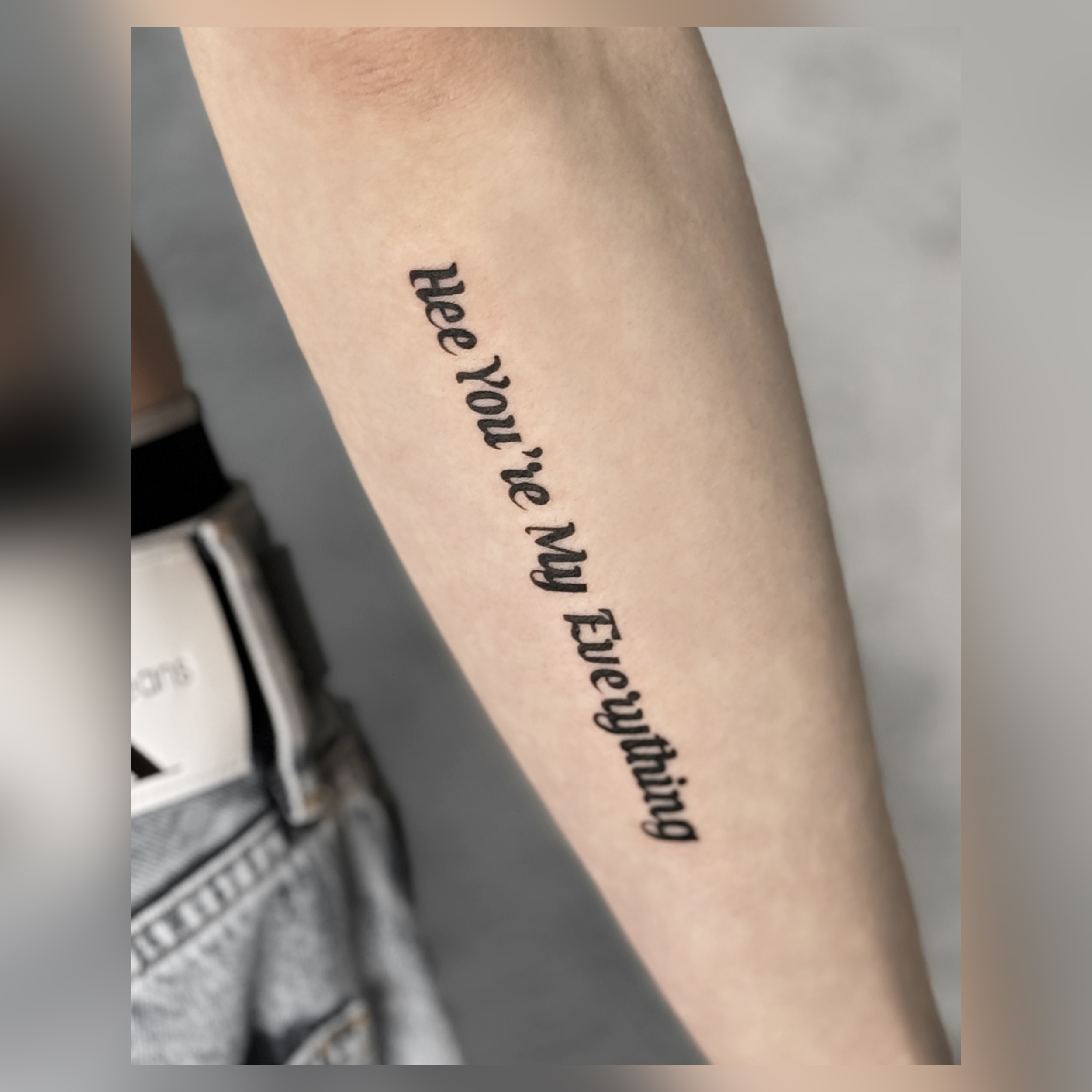 Lettering tattoo with serif typography along forearm