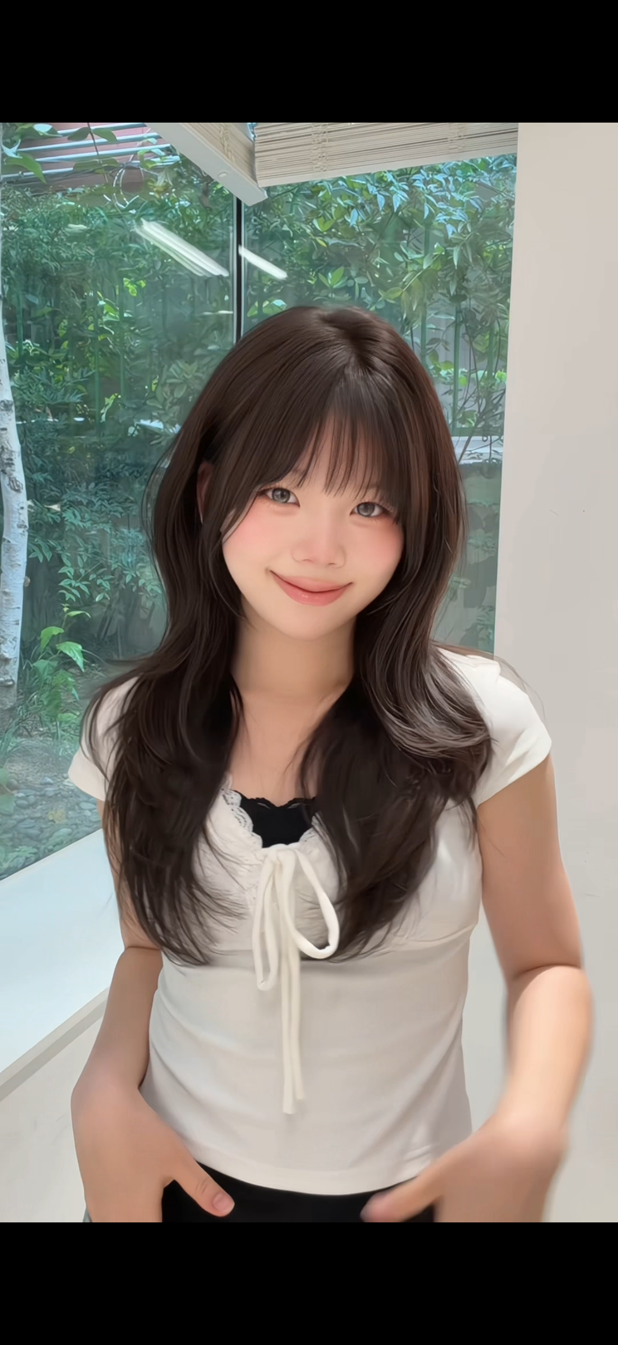 Soft natural hair styling with voluminous waves and curtain bangs.