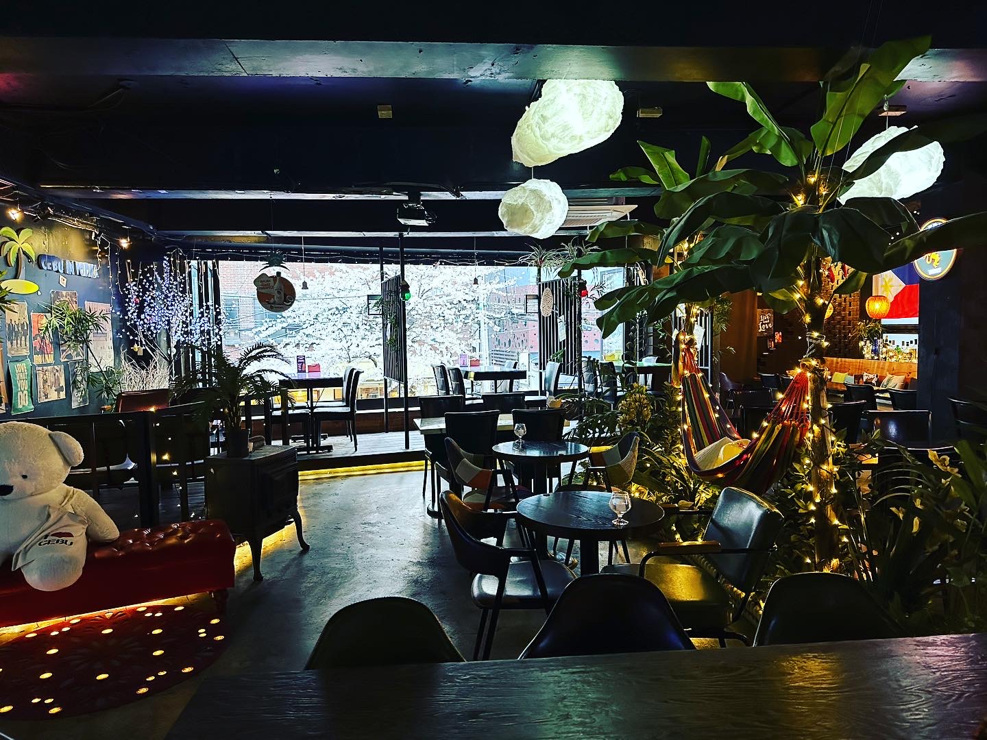 Dimly lit indoor lounge area at Cebu in Vodka with fairy lights and tropical banana trees