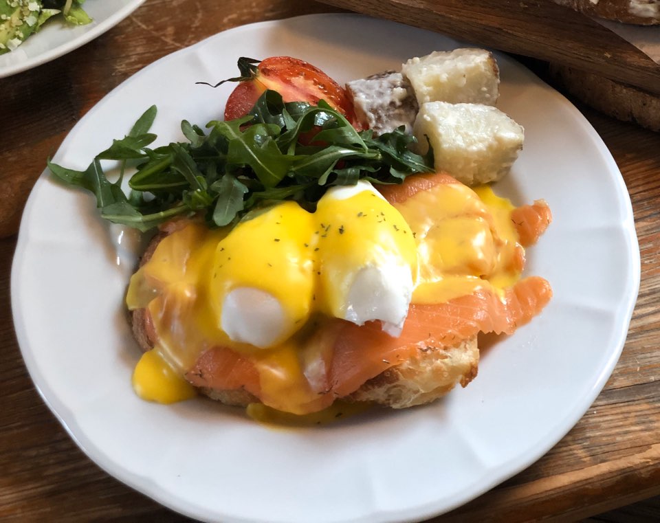Eggs benedict with smoked salmon on a white plate served at a table