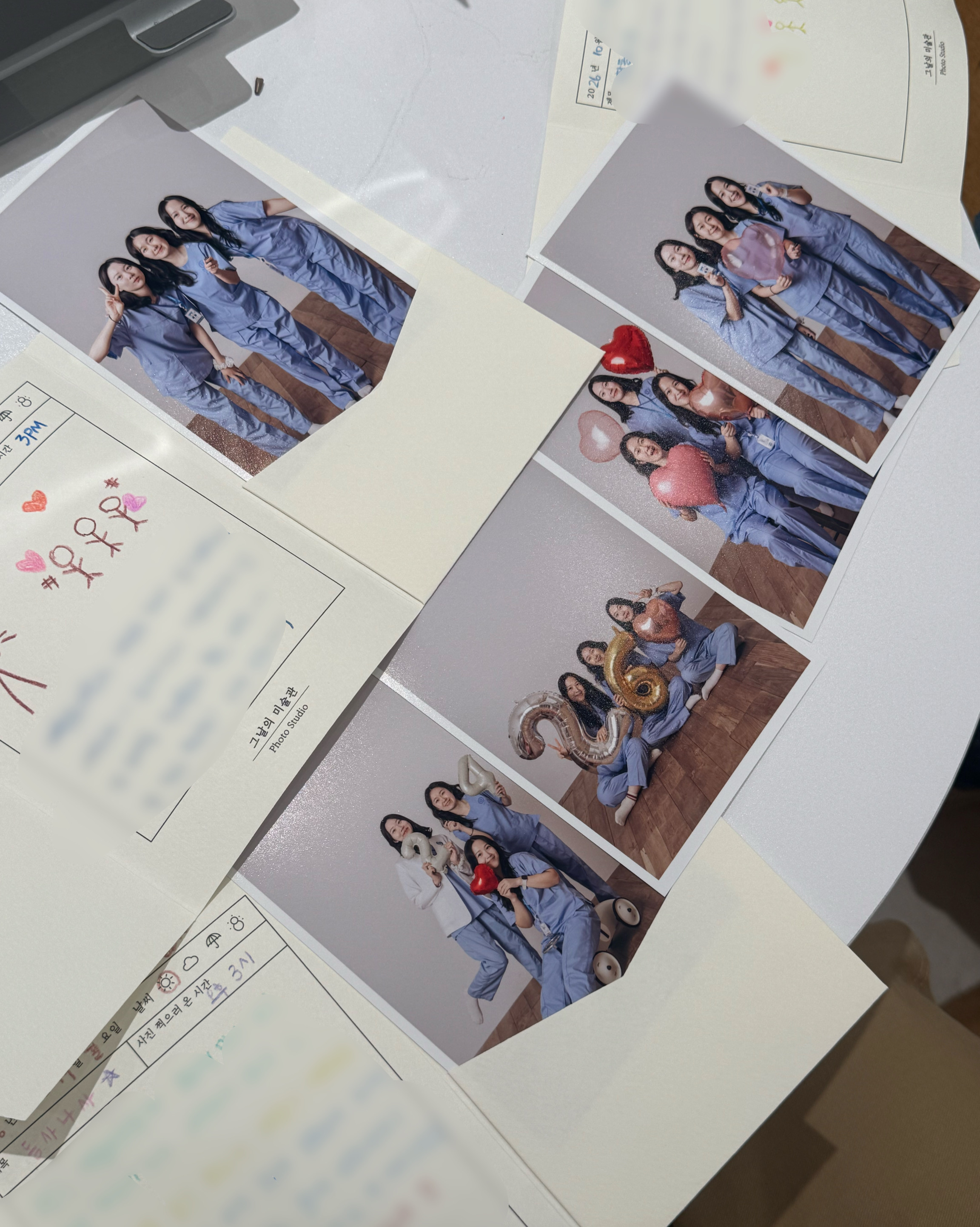 Several printed photo booth pictures arranged on a table at a photo studio