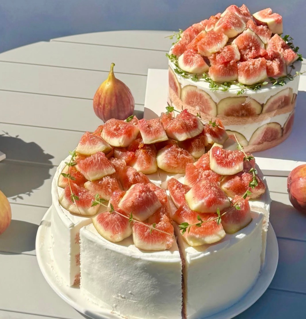 Tiered fresh fig cakes decorated with herb sprigs