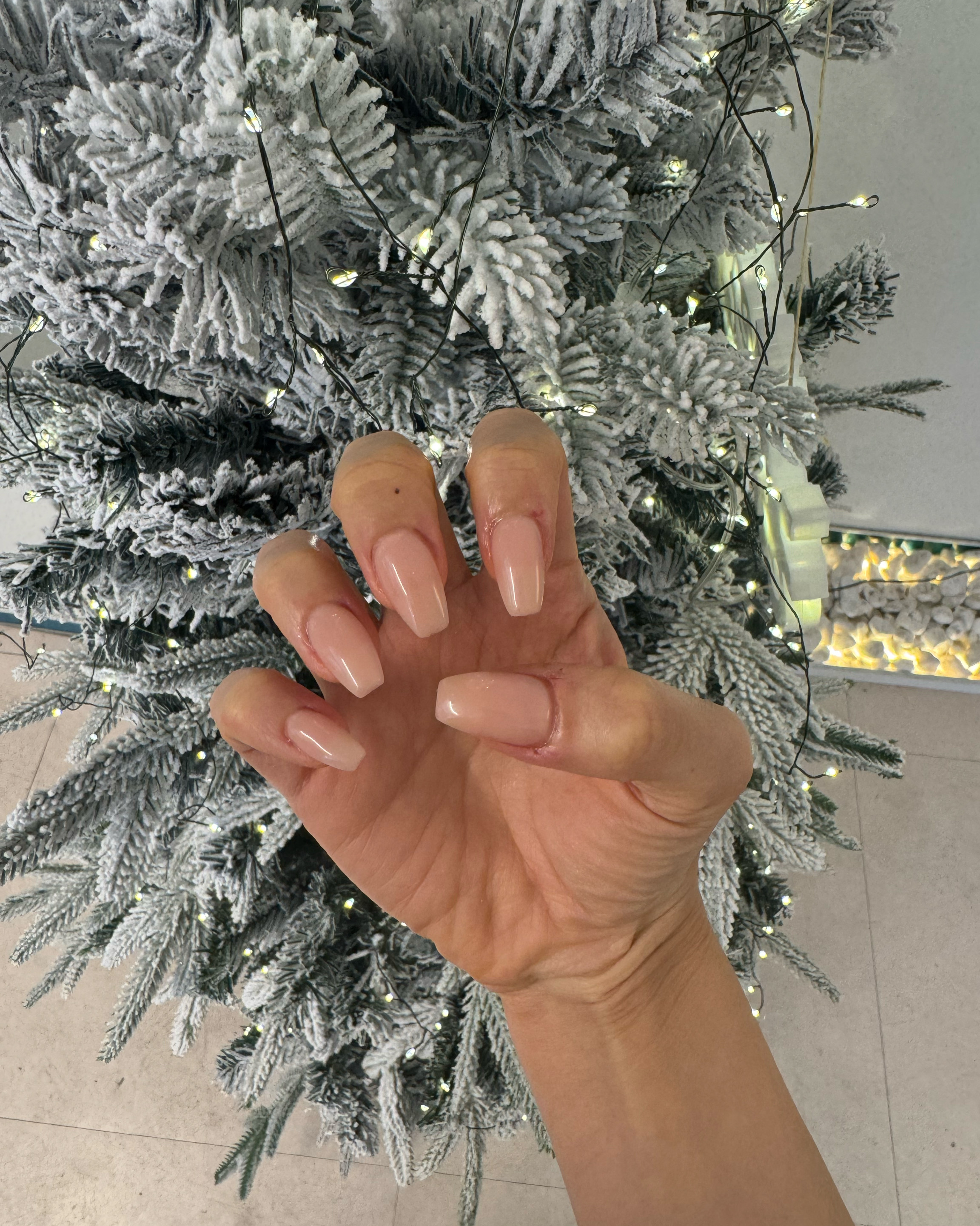 Glossy nude coffin-shaped nail extensions