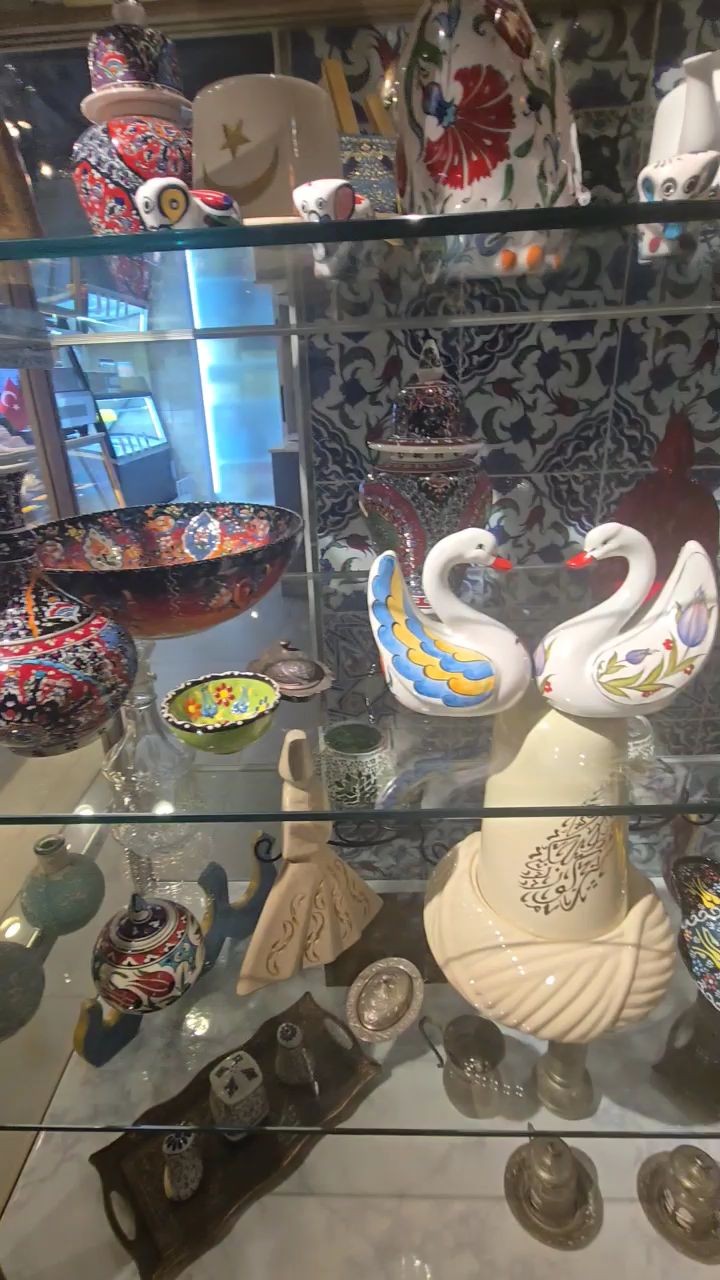Traditional hand-painted Turkish ceramic bowls and ornamental figurines in display cabinet