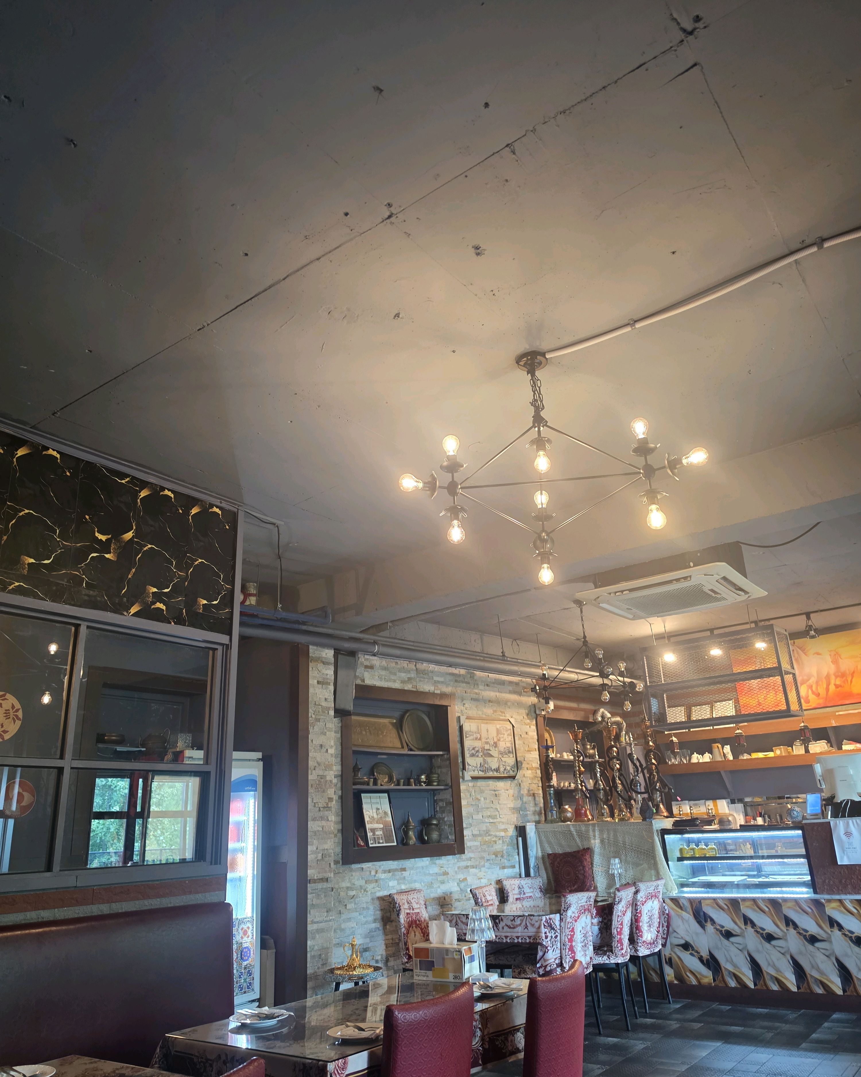 Warm restaurant dining space with geometric pendant light fixture