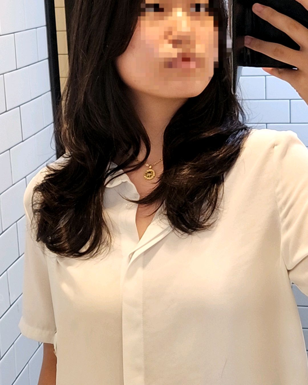 Client selfie showcasing fresh long wavy hair texture in studio setting