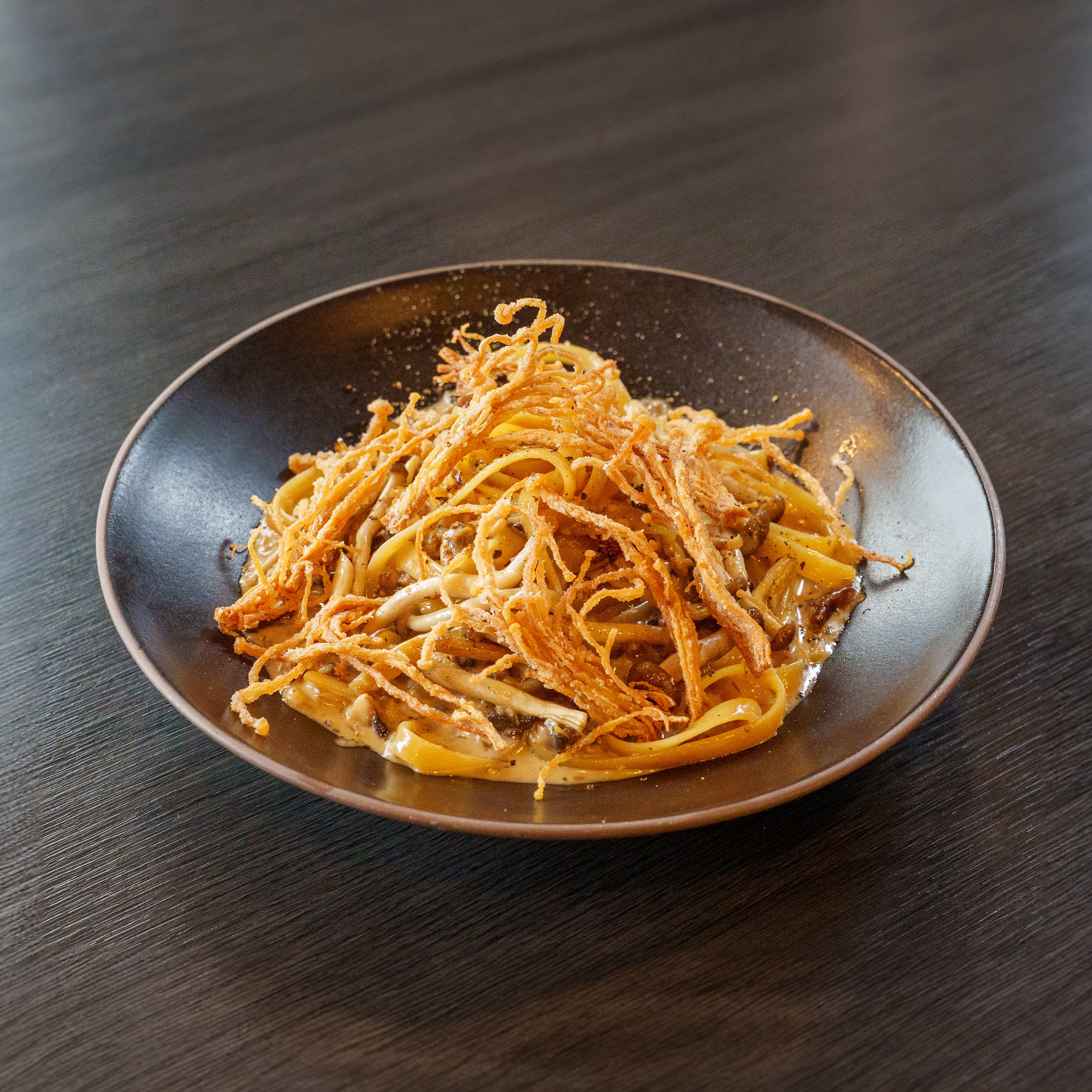 Linguine pasta tossed with savory mushrooms and crispy toppings