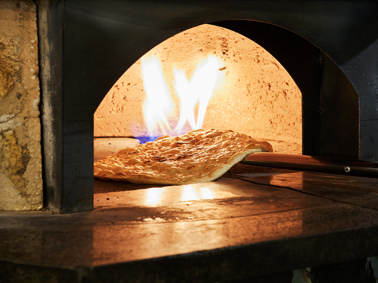 Dough being baked inside a wood-fired oven