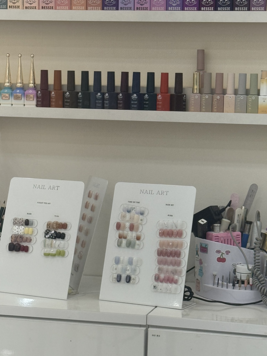 Organized professional nail drill tools and sample display in the salon