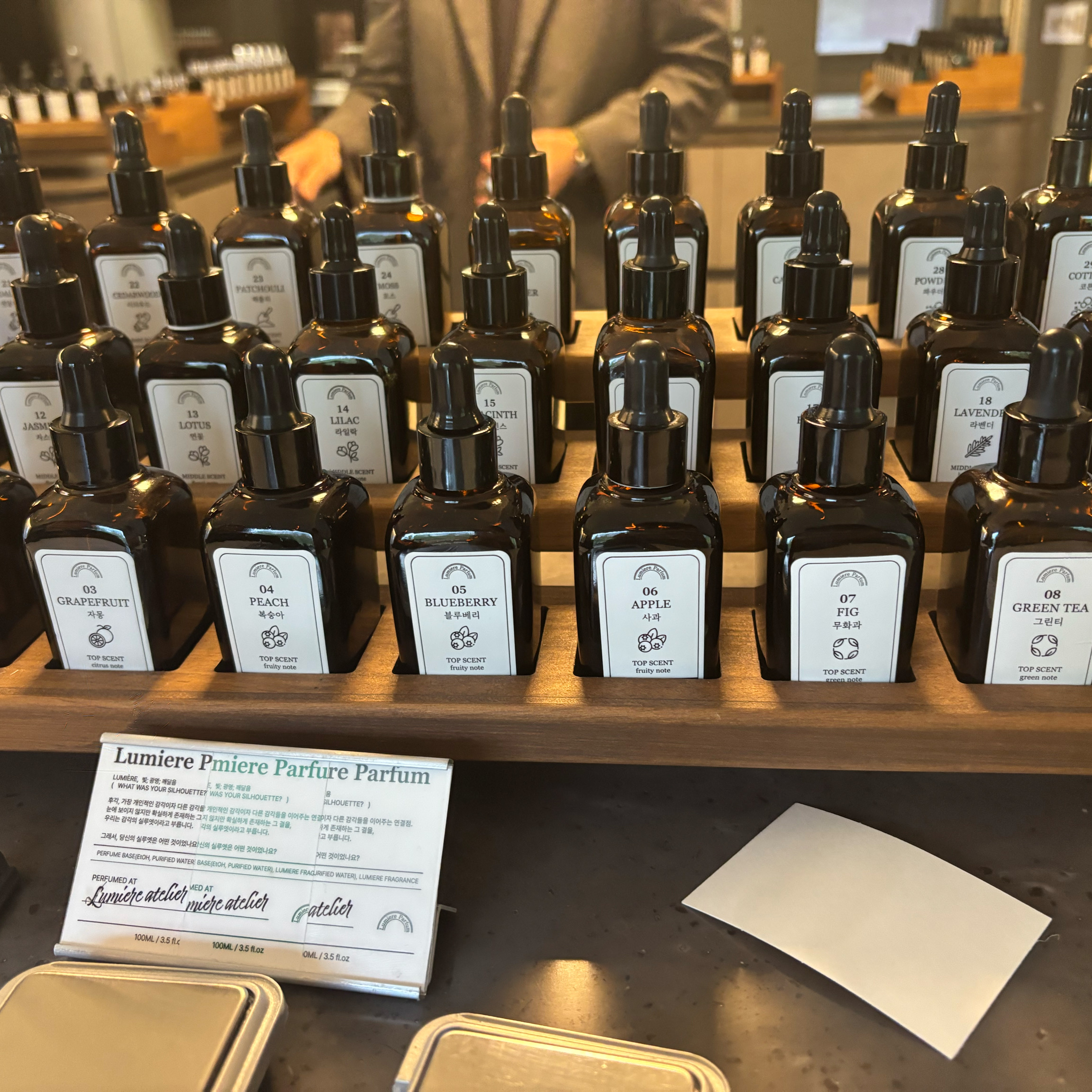 Amber glass dropper bottles organized in neat rows on a tiered wooden display in the studio