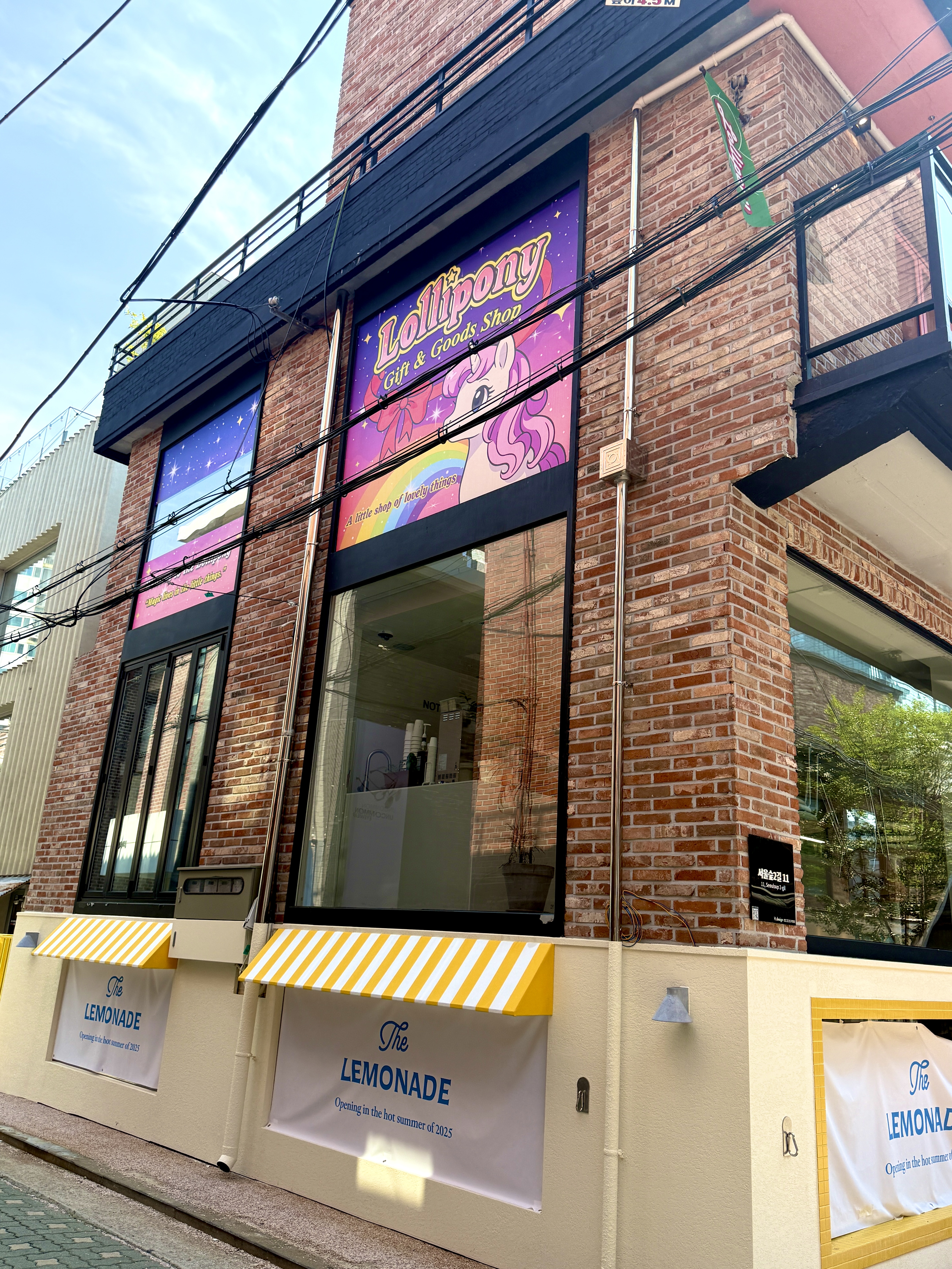 Lolli Pony signs mounted high on the second floor of the brick building