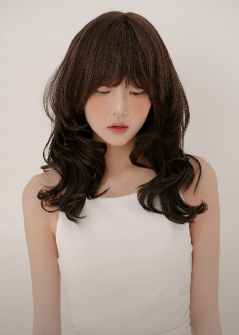 Layered wavy dark brown hair featuring soft bangs