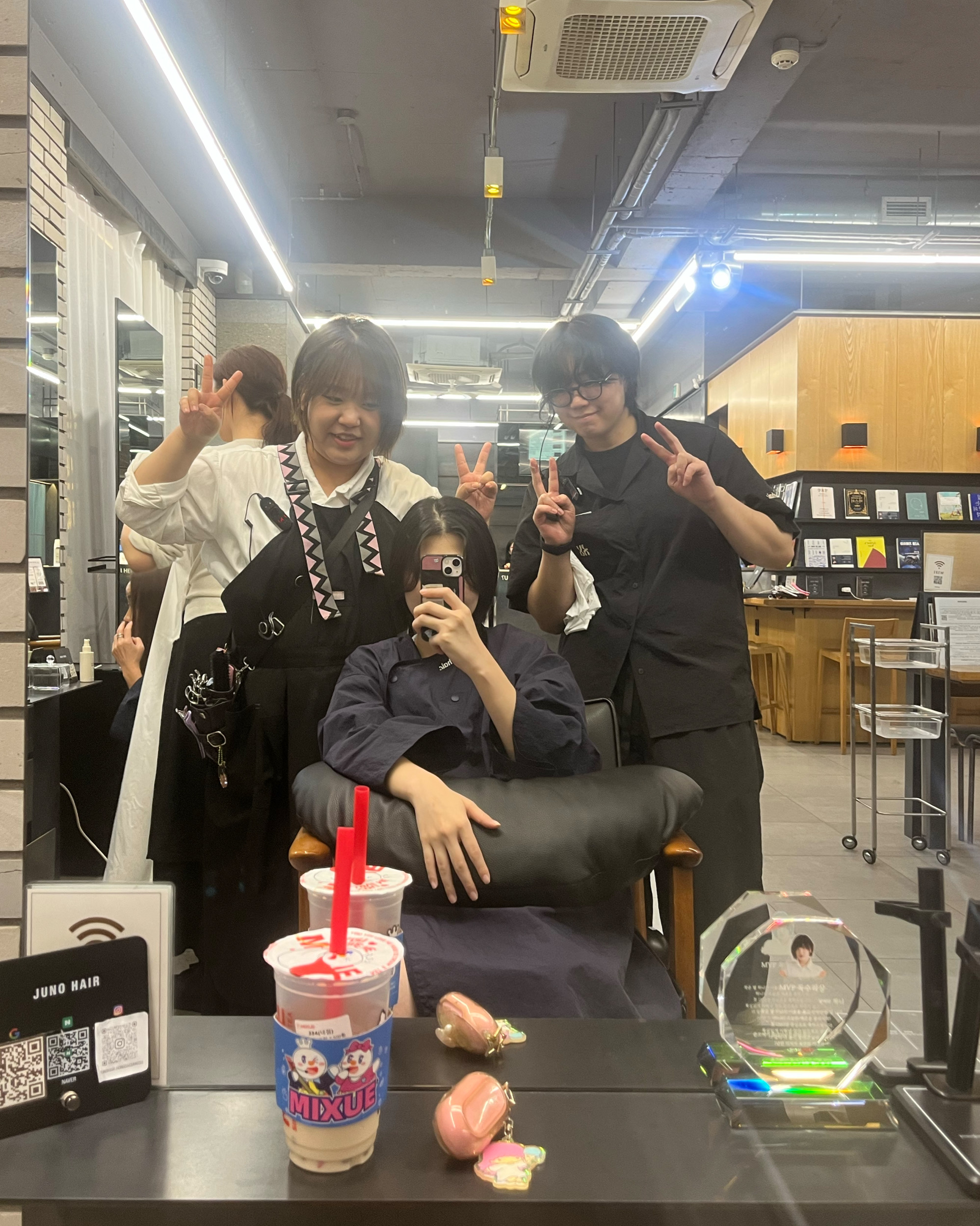 Stylists and client inside the salon station mirror