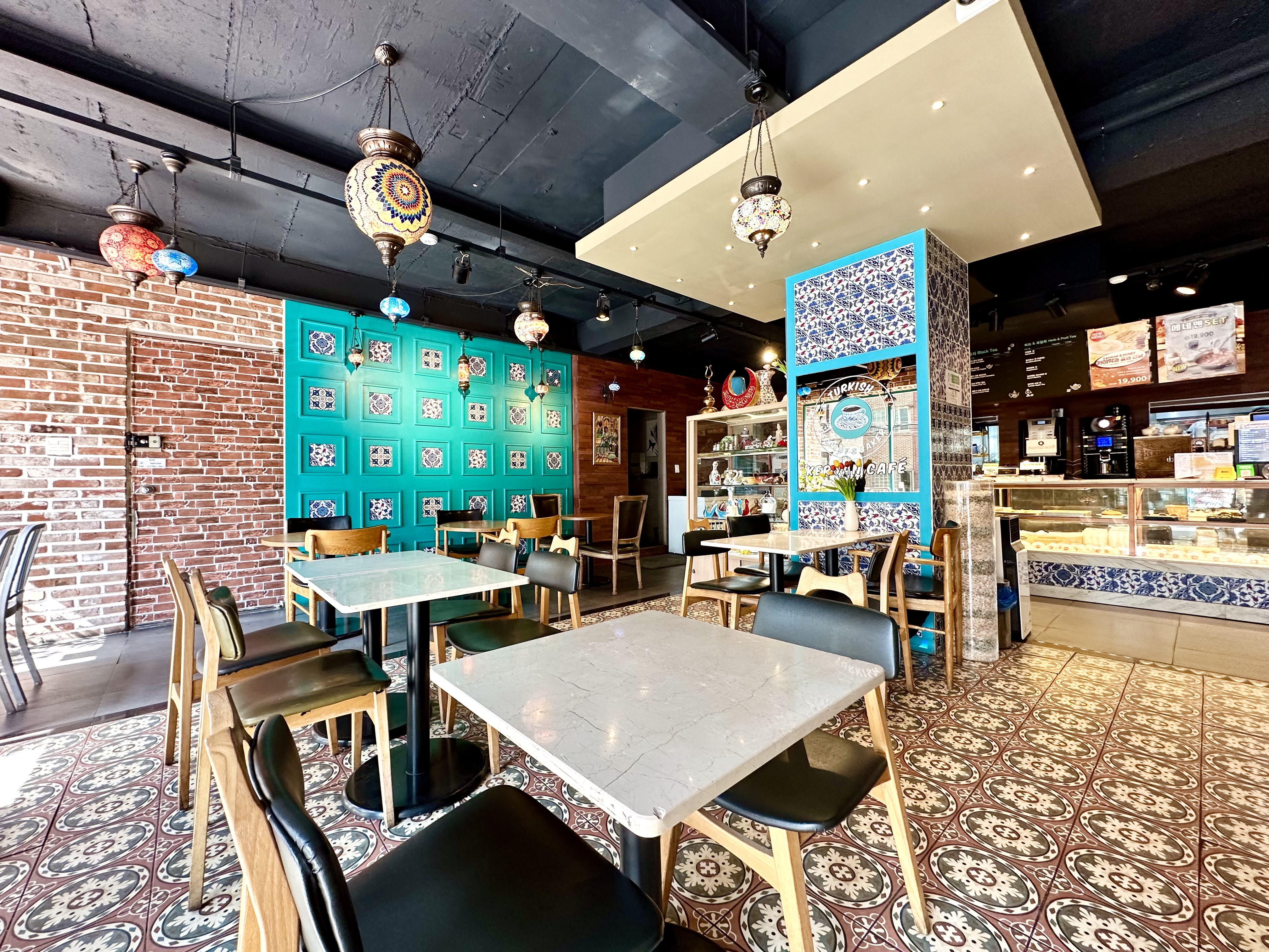 Interior of Kervan Cafe with tiled walls, patterned floors, and hanging lamps