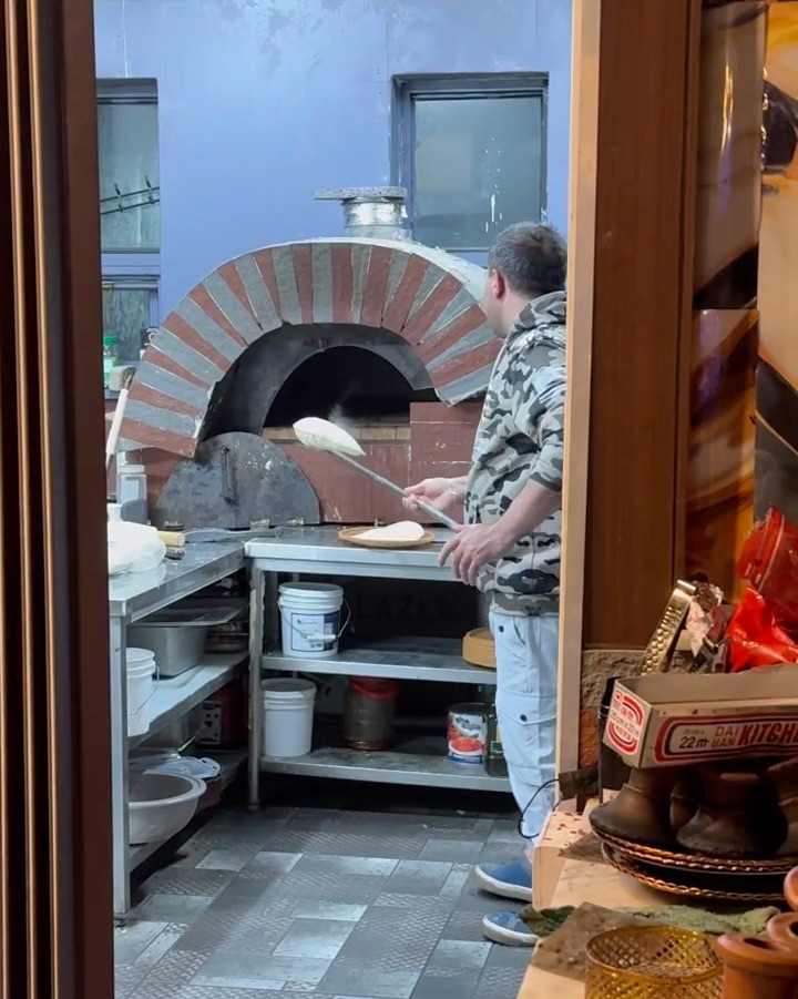 Flatbread being baked fresh inside traditional brick oven