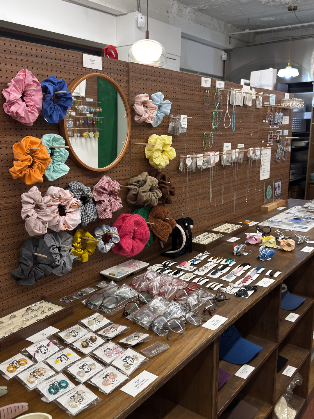 Fabric scrunchies and eyewear collection on pegboard display