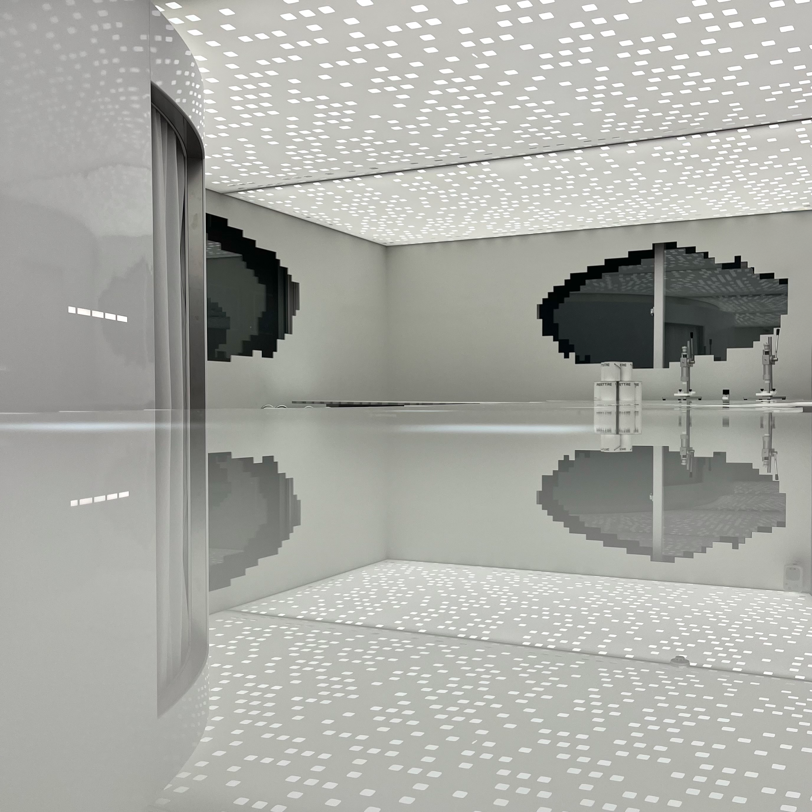 Architectural studio interior with curved white surfaces and reflective lighting