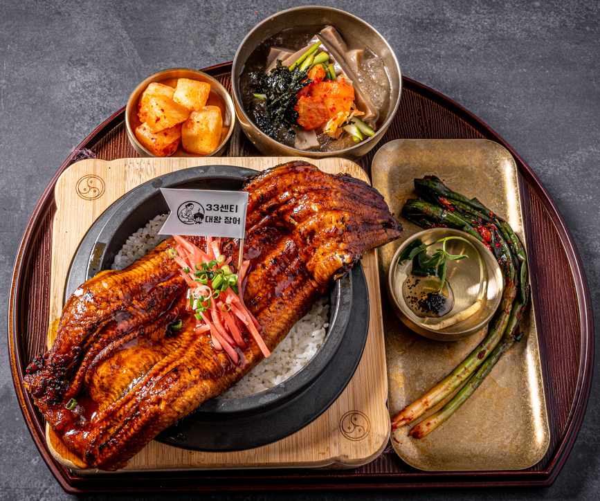 Signature grilled eel stone pot meal served with traditional side dishes
