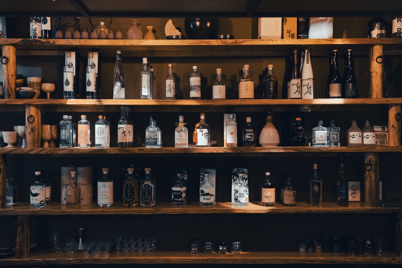 Wooden shelves displaying various bottles of spirits and liquor at Namsan Sul Club.