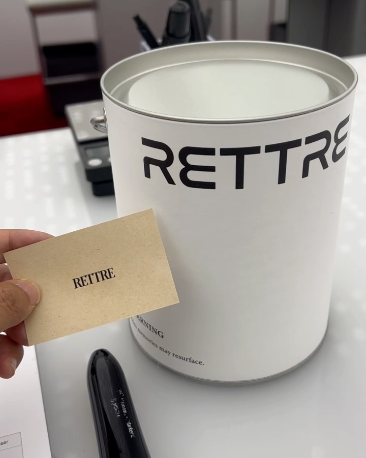 Branded RETTRE cylinder packaging card and formulation scale on studio desk