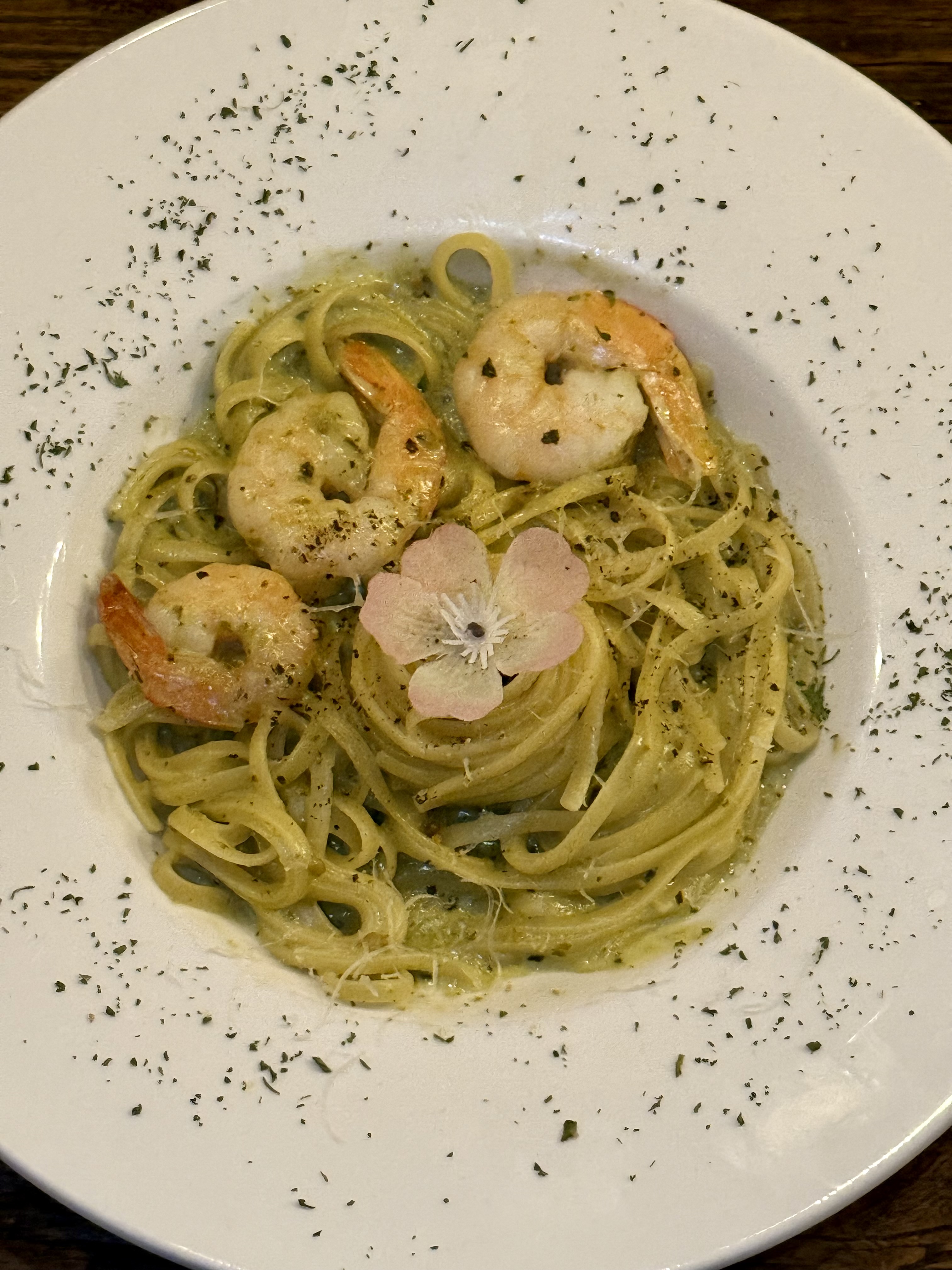 Shrimp linguine pasta garnished with an edible pink flower