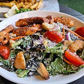 Fresh salad plate topped with grilled chicken, cherry tomatoes, and croutons