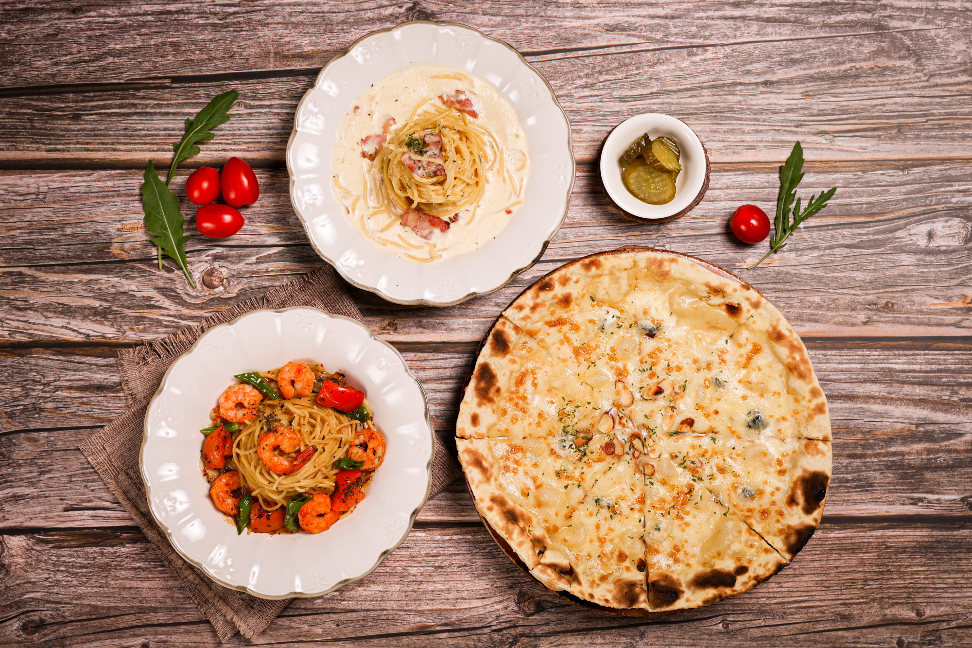 Pasta and pizza setting on a wooden table