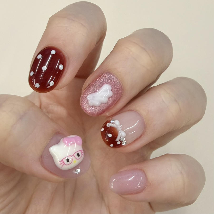 Custom gel nail art set featuring 3D character charms, polka dots, and glitter elements