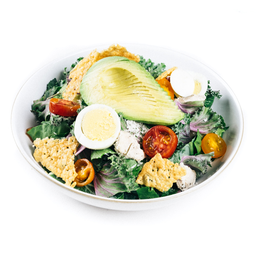 Avocado egg salad bowl with crispy cheese crackers on greens