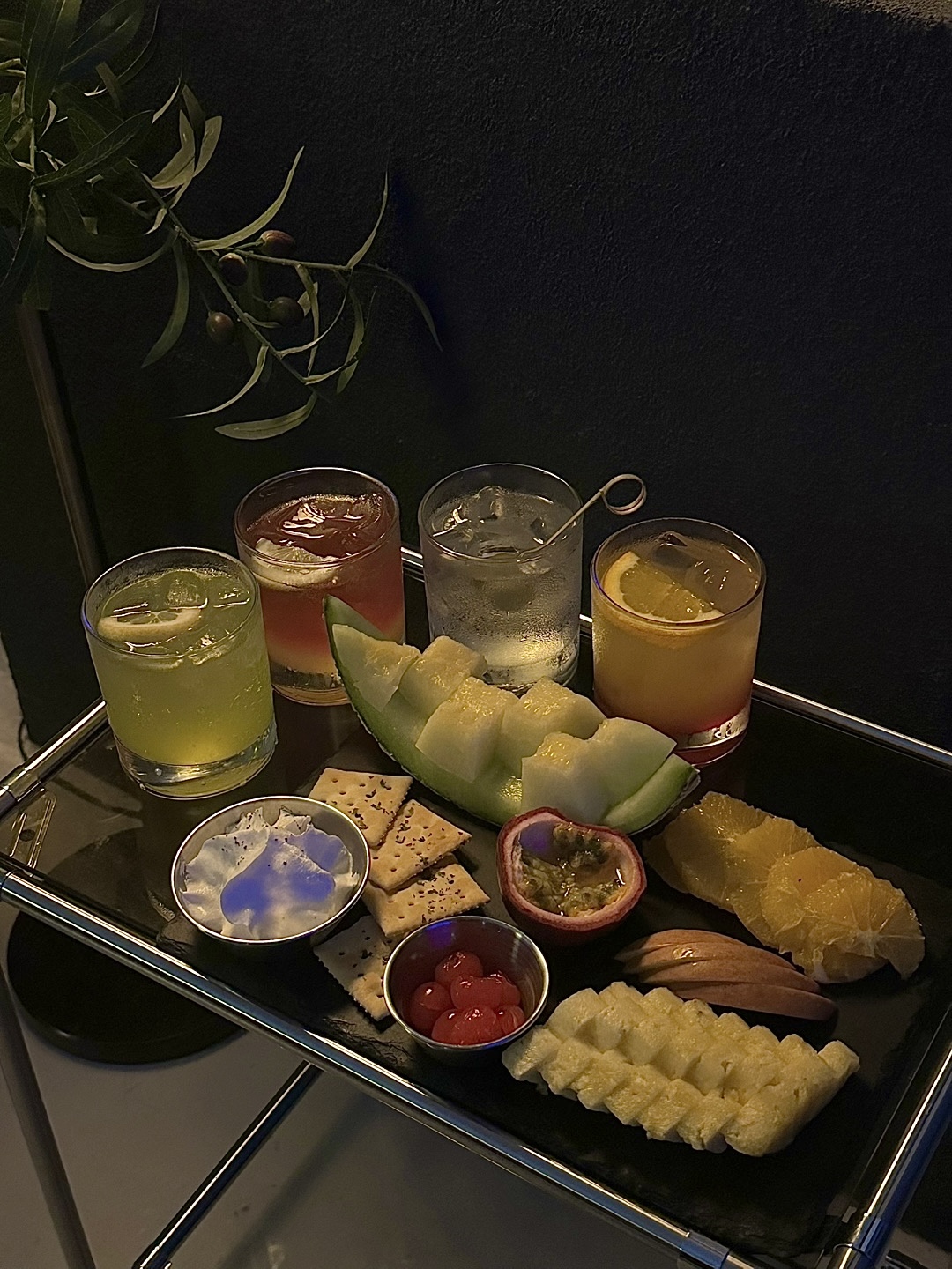 Fresh fruit platter with cherries, melon, passion fruit, crackers, and house cocktails