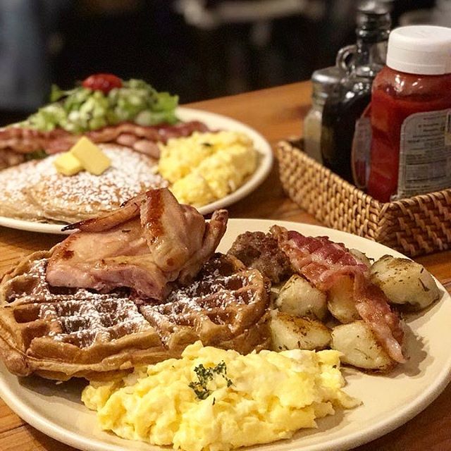 Belgian waffle topped with roasted chicken, eggs, bacon, and potatoes