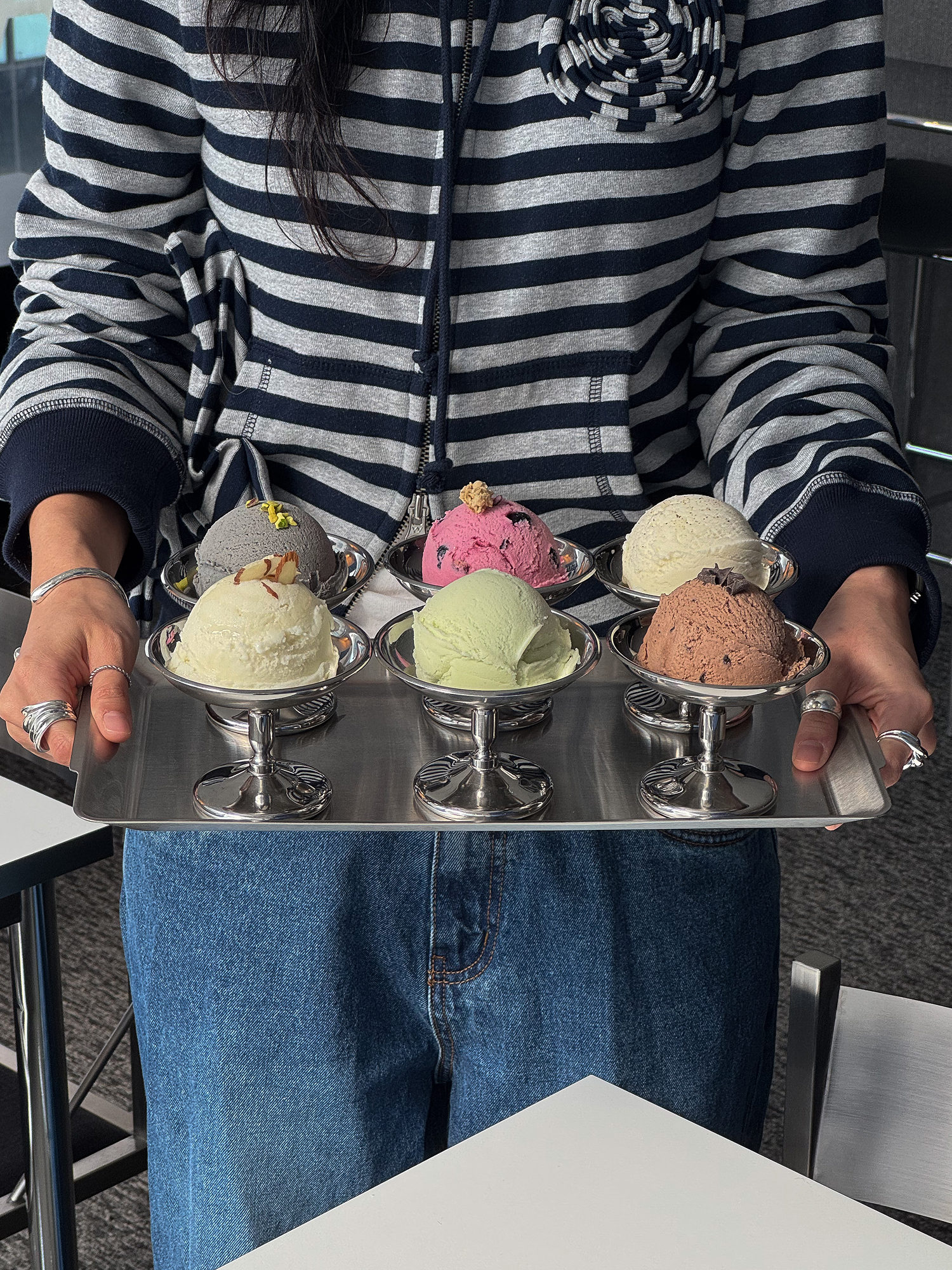 Silver serving tray with six different scoops of handcrafted ice cream in metal pedestal bowls at Waa
