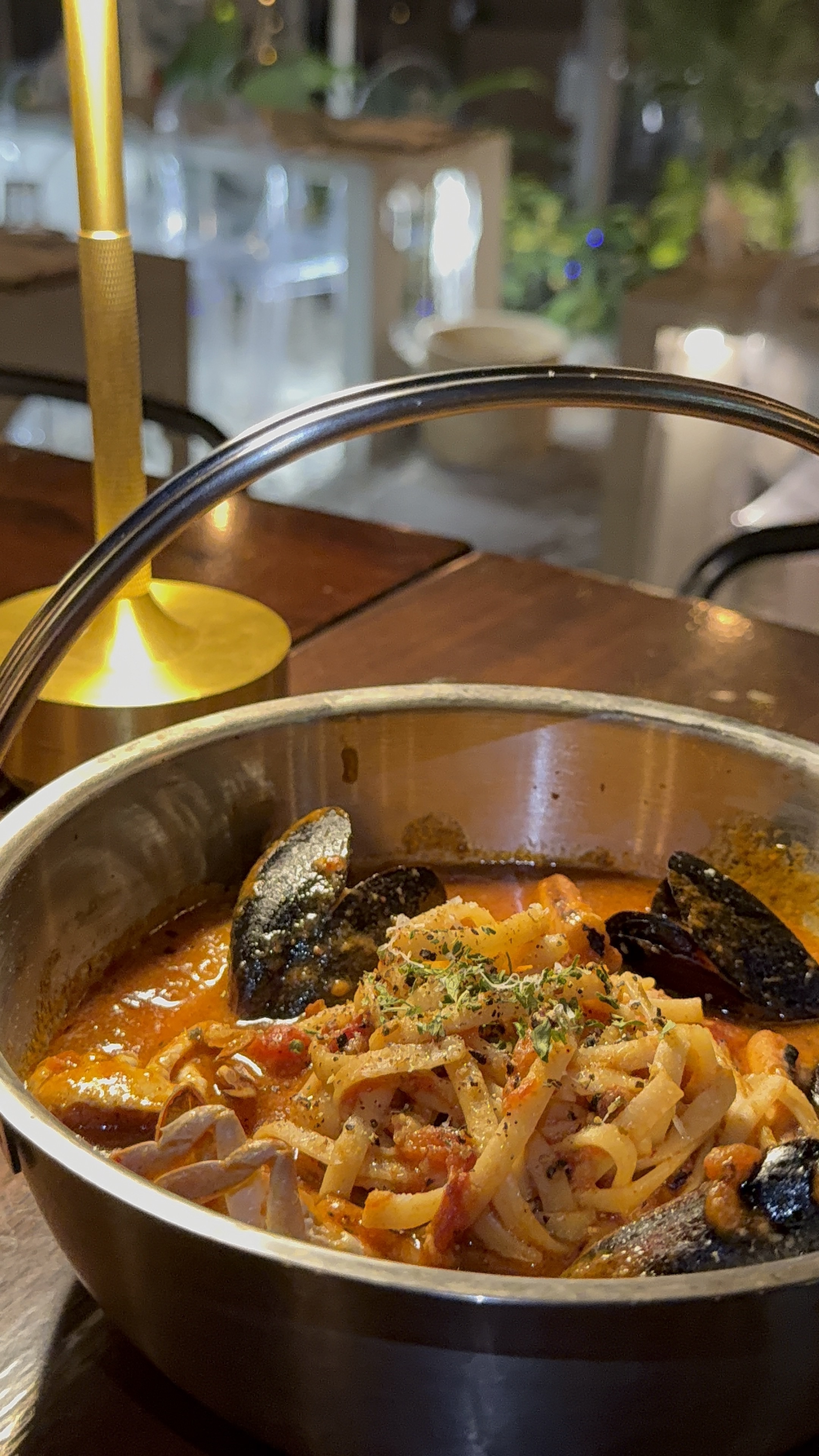 Seafood rosé pasta served in a metallic pot with mussels and savory sauce