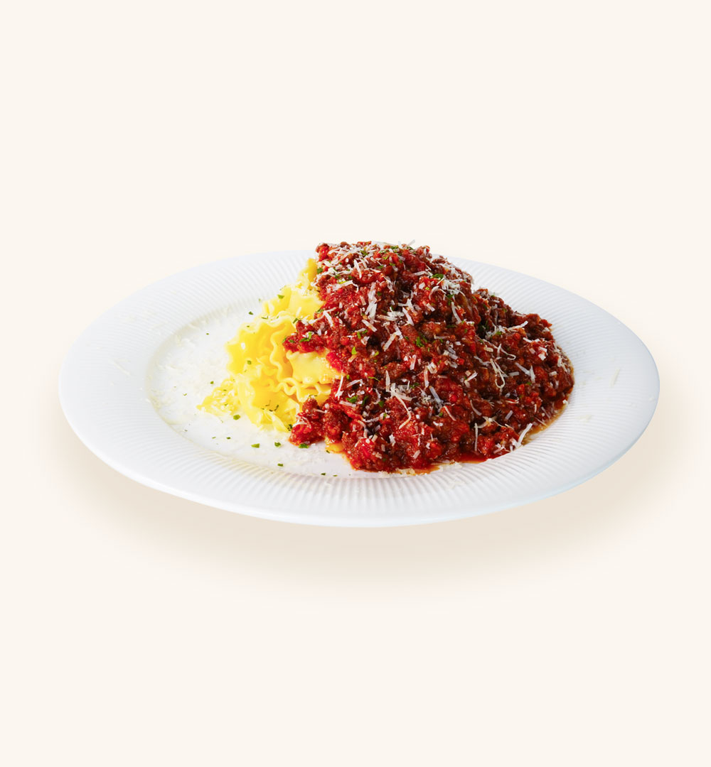 Wavy mafaldine pasta topped with hearty bolognese meat sauce and grated cheese