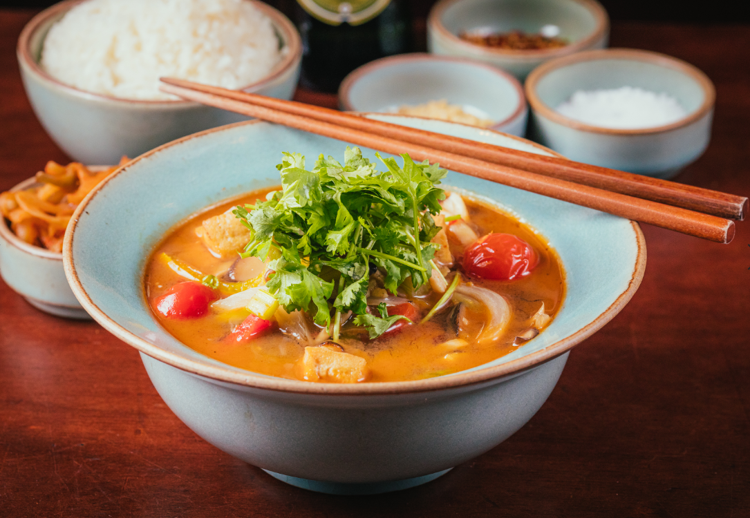 Aromatic Tom Yum soup topped with fresh cilantro
