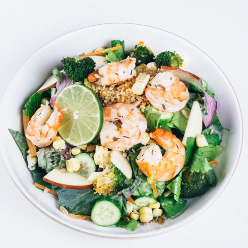 Grilled shrimp salad bowl with lime, broccoli, and crisp apple slices