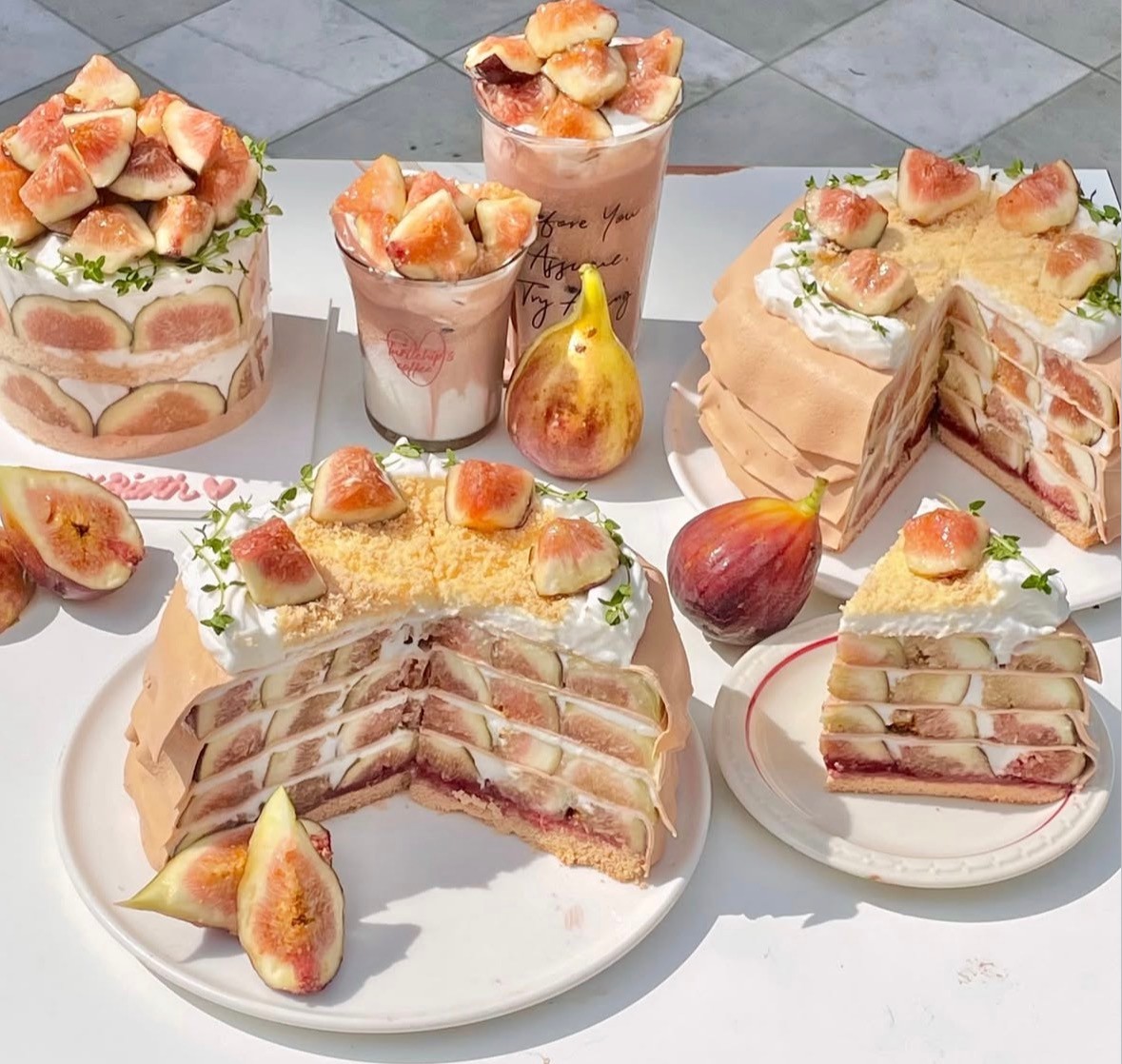Fresh fig desserts and sliced cakes arranged on outdoor table