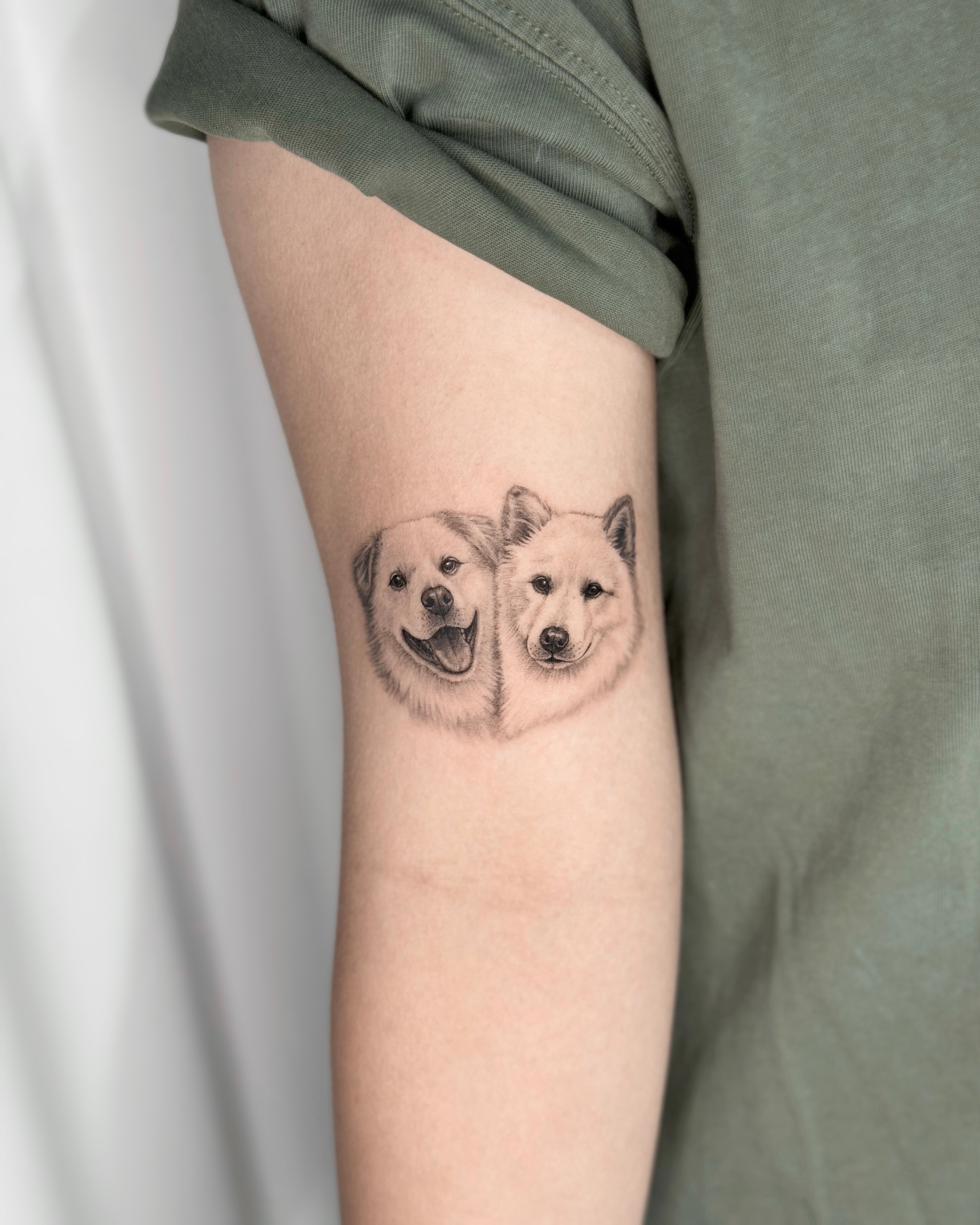 Realistic fine-line pet dog portrait tattoo on upper arm