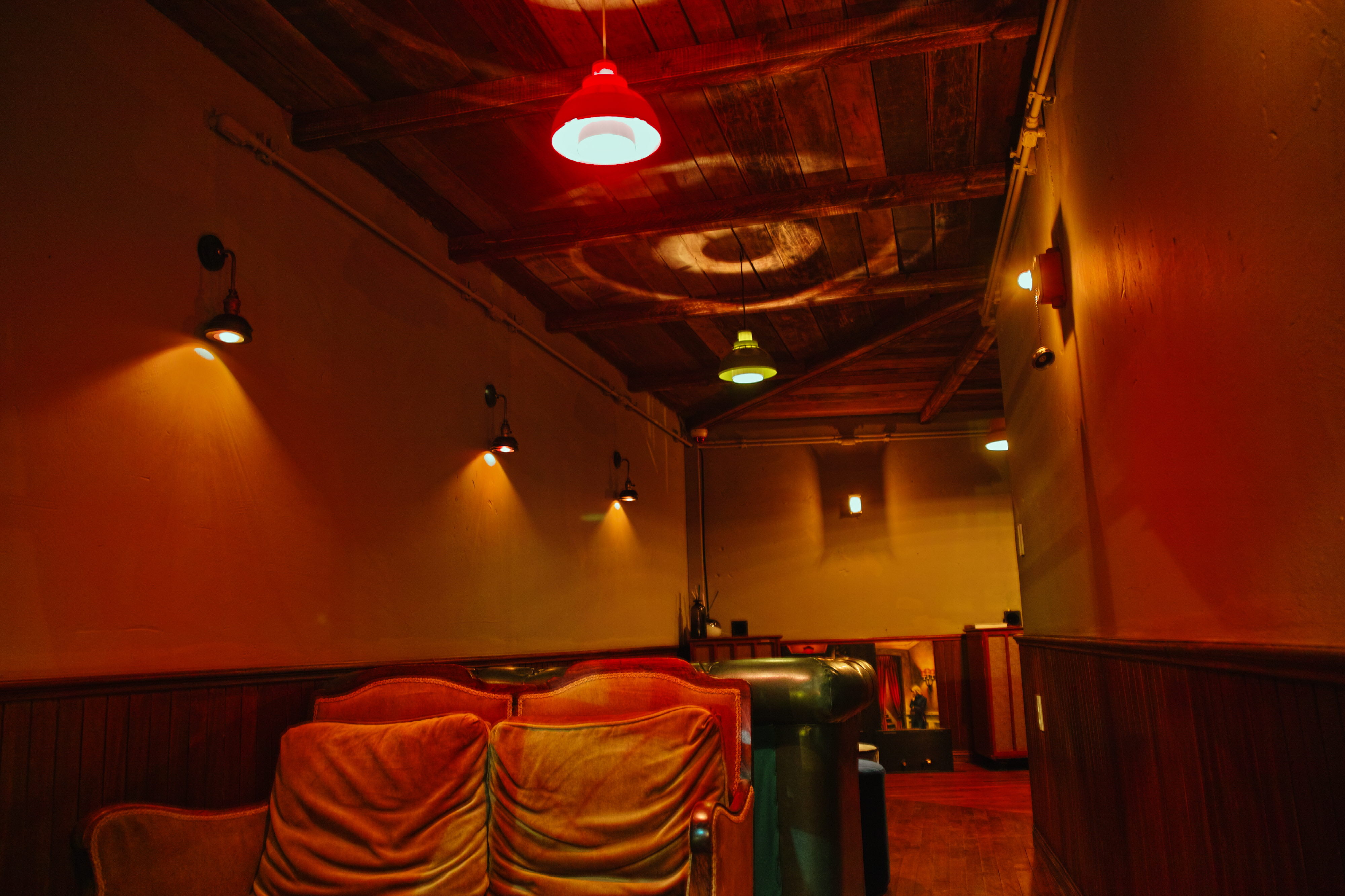 Brown tufted leather seating, wood paneling, and warm ambient lamps.