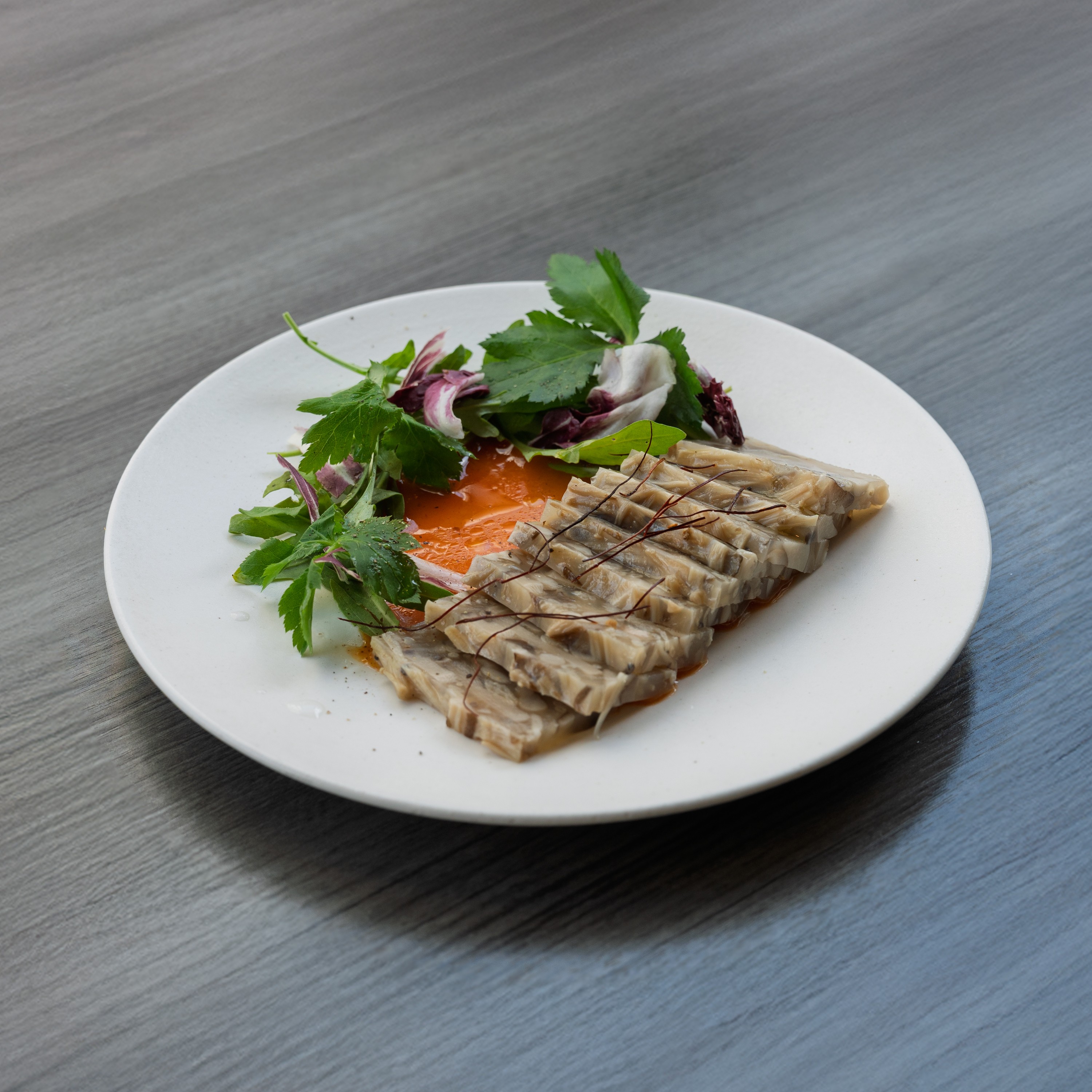 Thinly sliced savory terrine with fresh garden greens