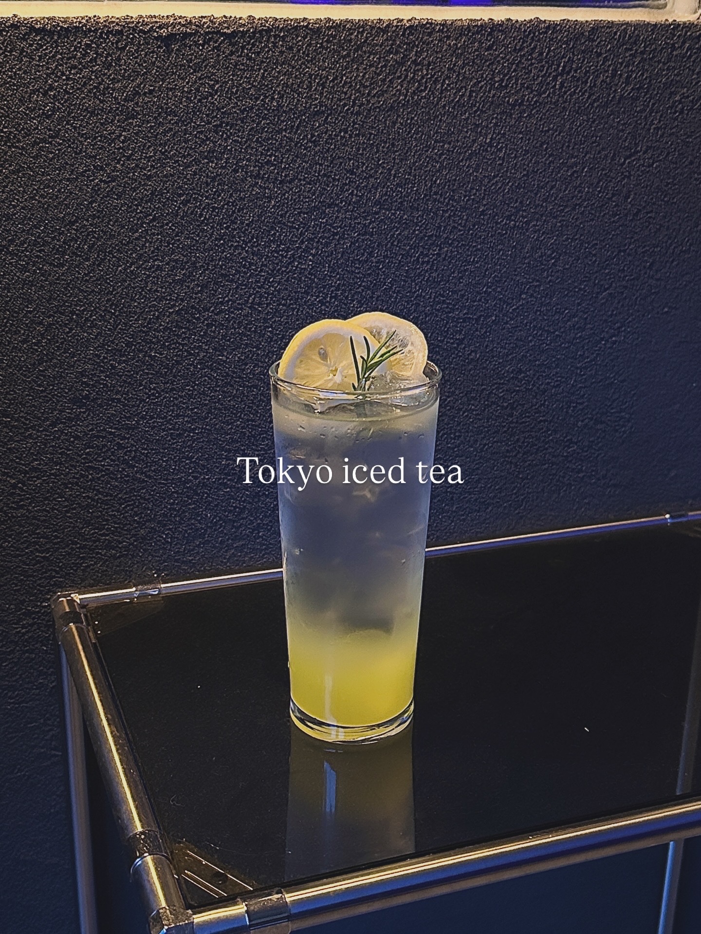 Tokyo Iced Tea cocktail with lemon slices and rosemary garnish in a tall glass