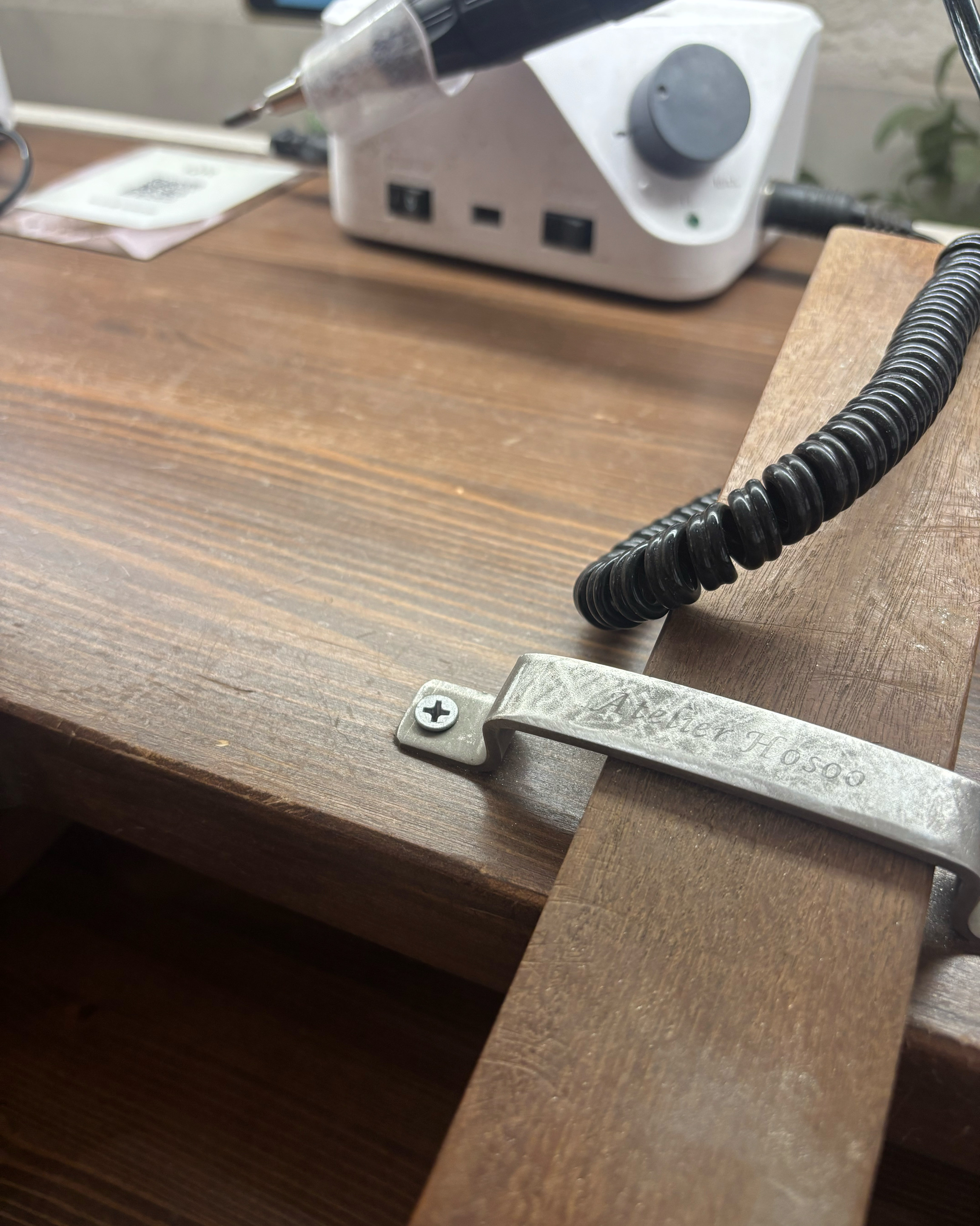 Close-up of wooden workbench with metal bracket and jewelry tools