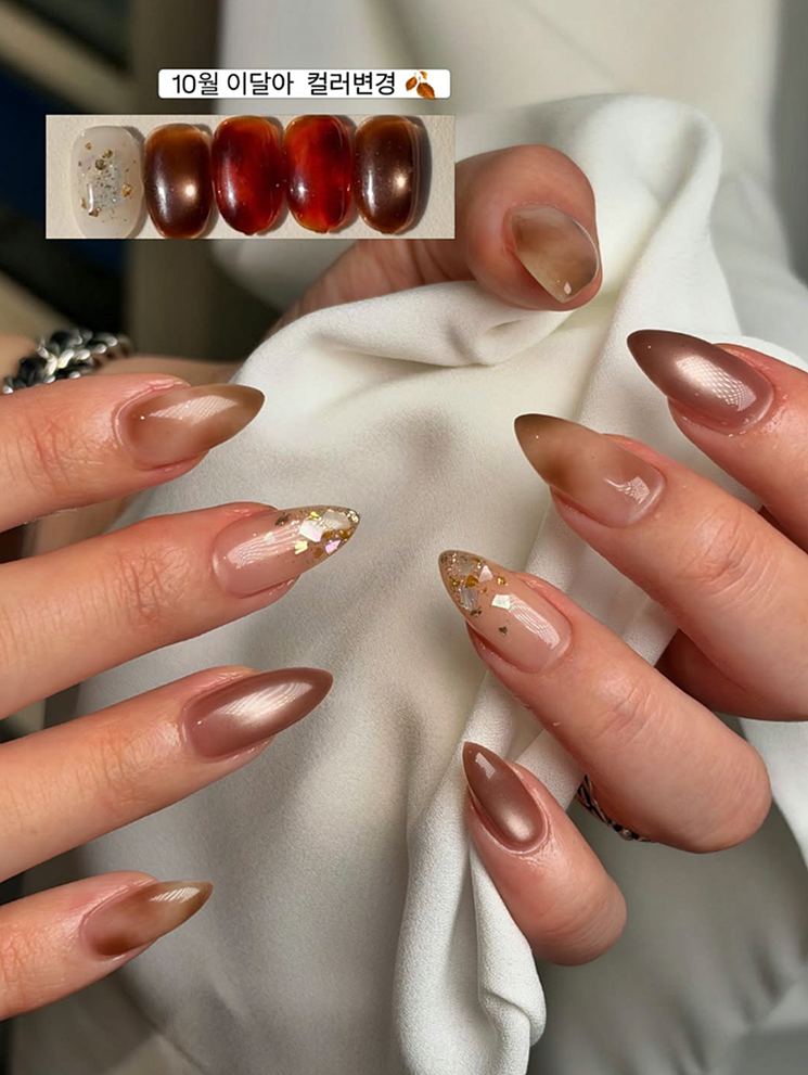 Almond-shaped nail design featuring brown, nude, and gold foil accents