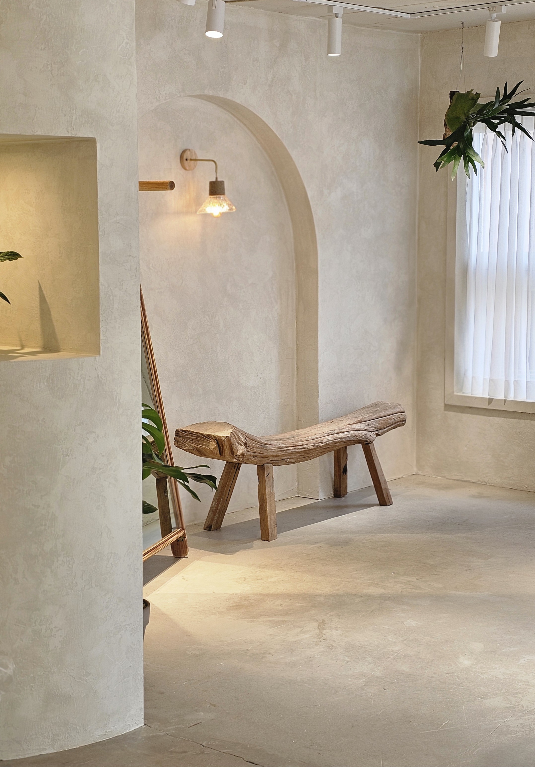 Minimalist studio interior with arched alcove, rustic wooden bench, and soft daylight at Alluve Ring Workshop
