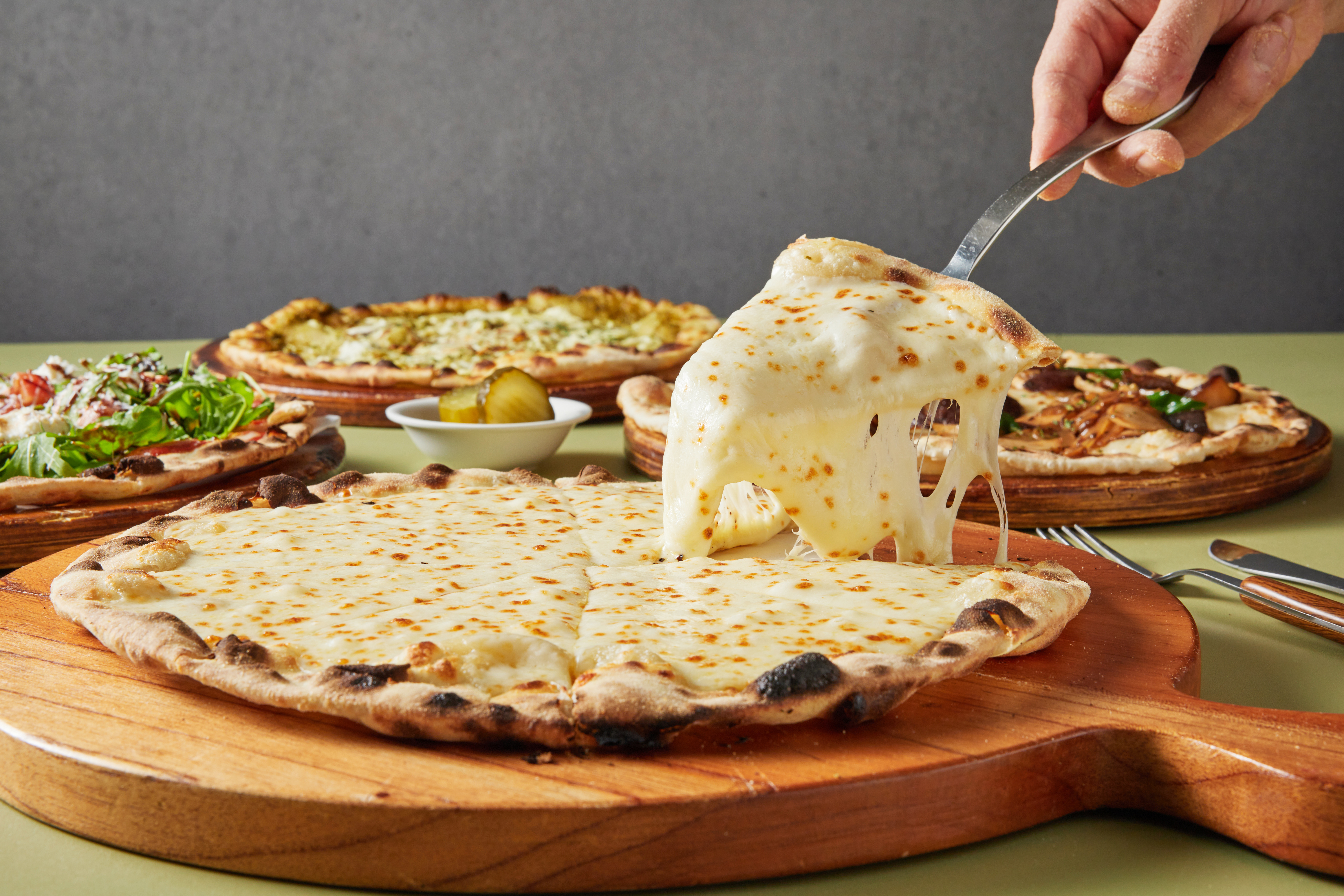 A slice of wood-fired pizza with stretching cheese