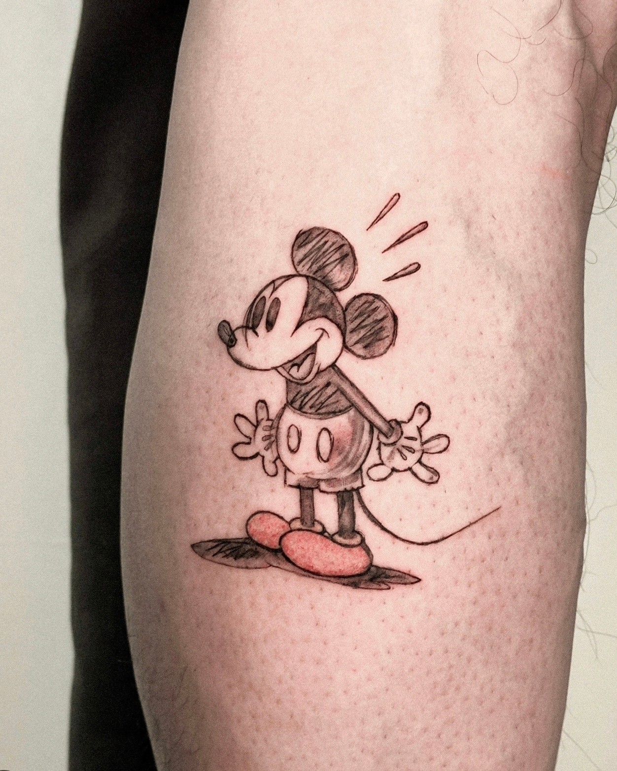 Sketch-style illustrative character tattoo on leg
