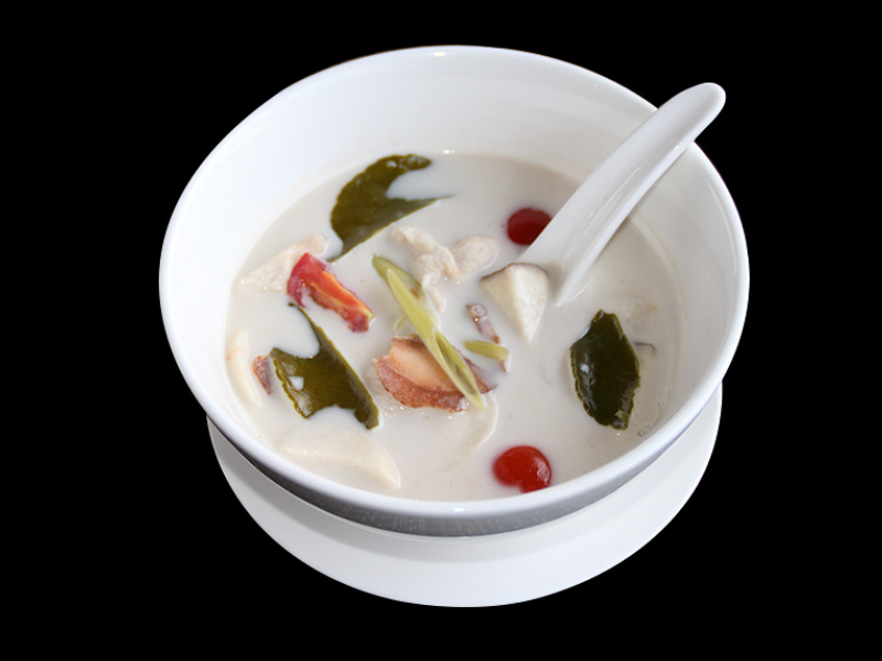 Creamy Tom Kha Gai coconut soup with galangal and fresh herbs