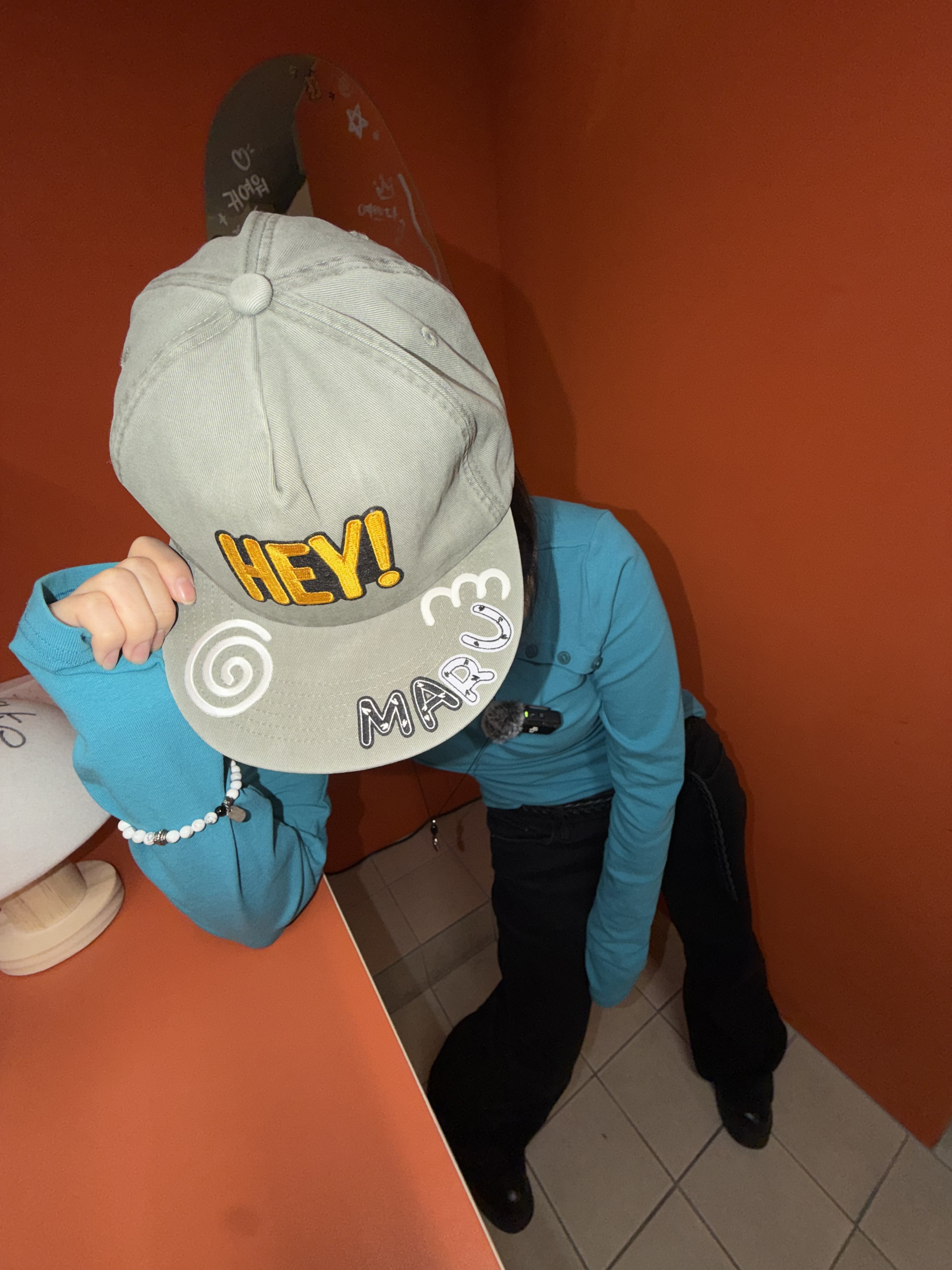 Custom baseball cap featuring yellow embroidery lettering created at the studio